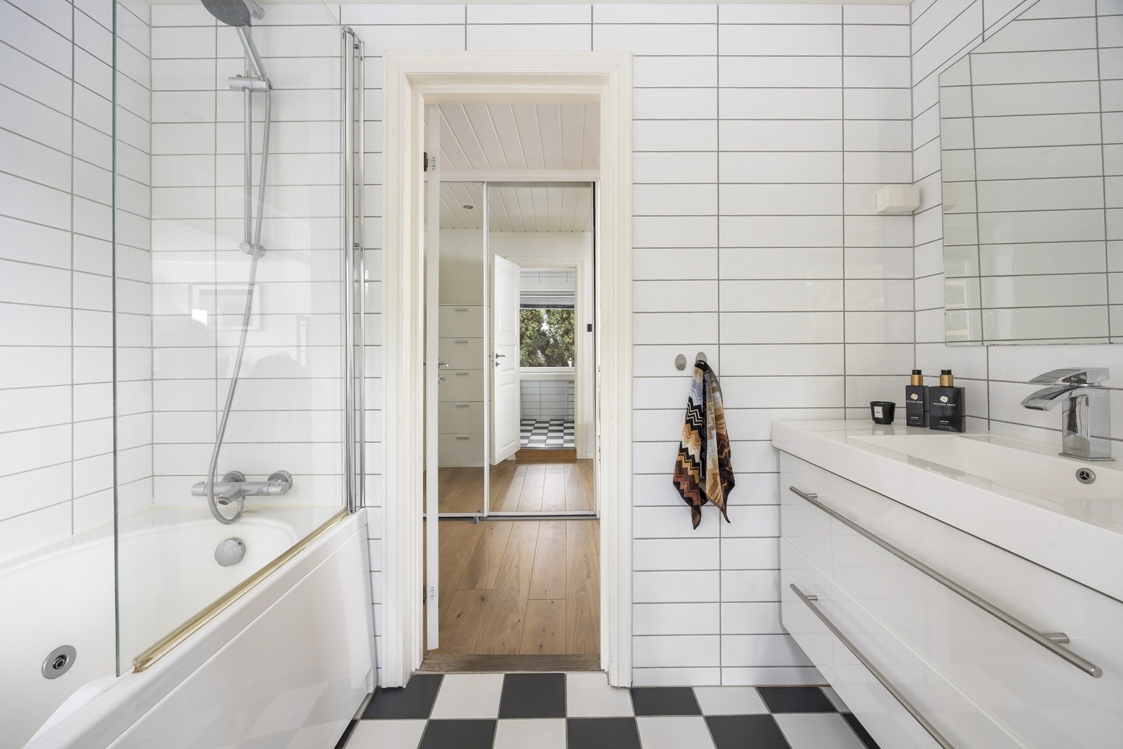 Badet er innredet med vegghengt klosett, servant nedfelt i innredning og badekar Galleribilde