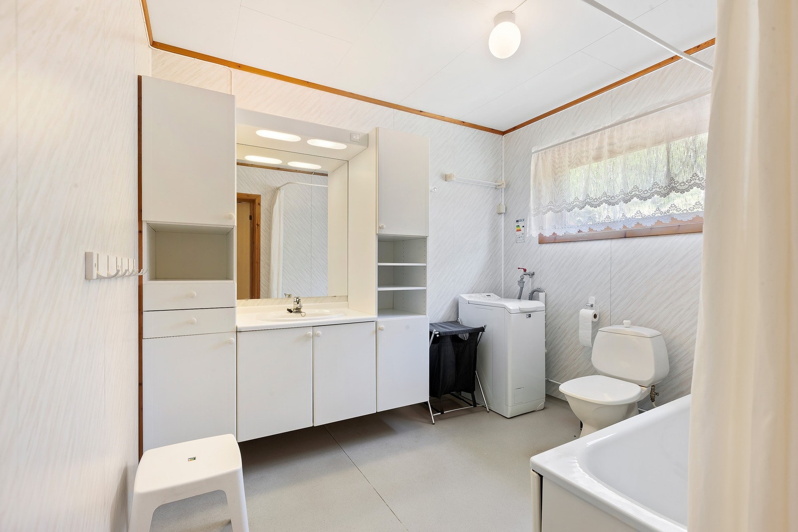 Badet har lys innredning med nedfelt servant med skap under, overskap med speil og lys over. Toalett, badekar og vaskemaskin. Varme i gulv. Galleribilde
