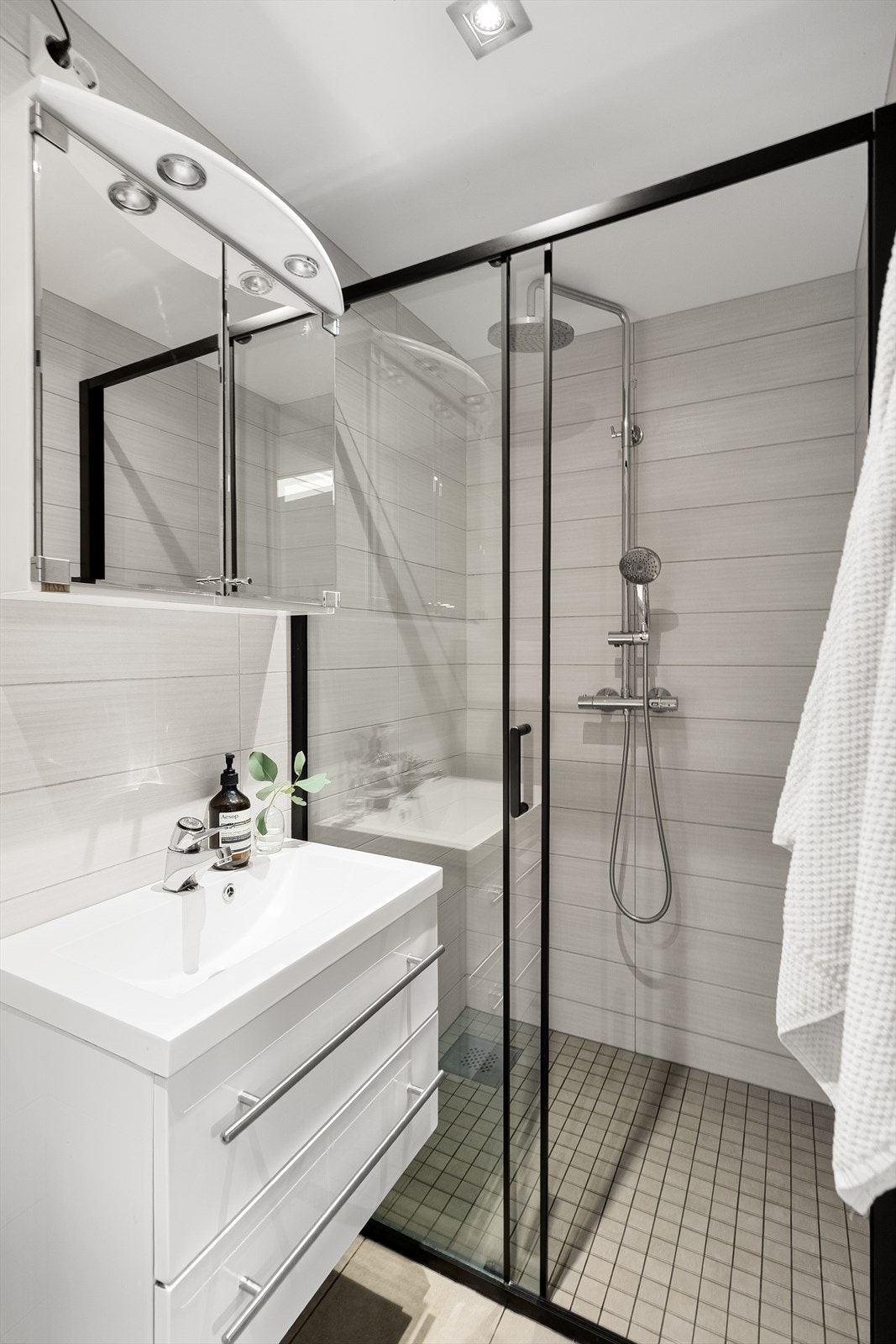 Badet er utstyrt med elektriske varmekabler i gulvet, dusjvegg og veggmontert klosett Galleribilde