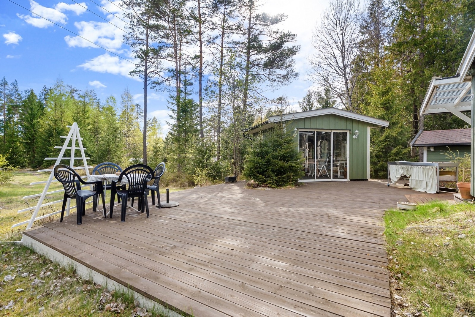 Stor terrasse mellom hagestue og hytte. Galleribilde