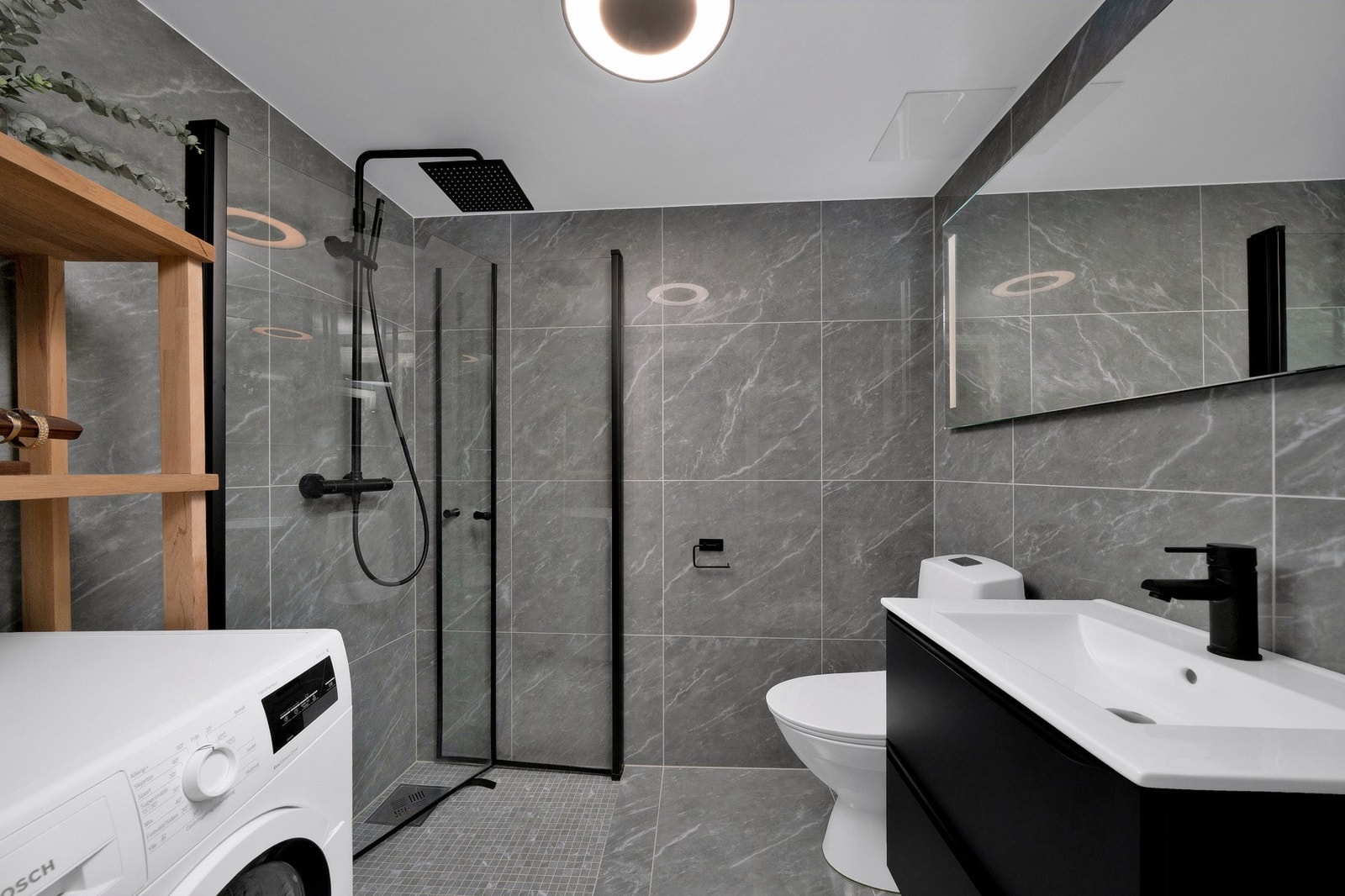 Badet er innredet med dusj, servantinnredning og toalett. Det er plass tll både vaskemaskin og tørketrommel. Galleribilde