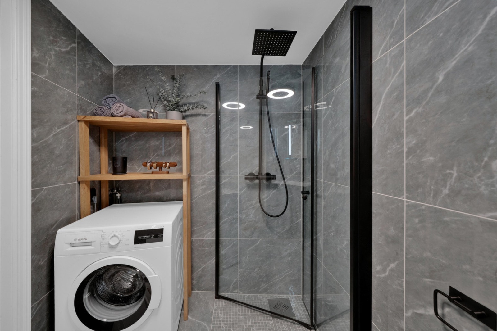 Badet ble renovert i 2020 med en moderne finish. Gulv og vegger er kledd med store, grå fliser i marmormønster. Galleribilde