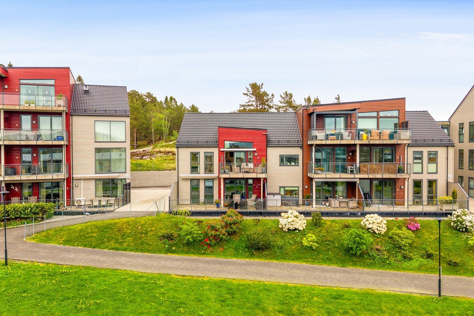 Nabolaget er pent opparbeidet med plen, blomsterbed, asfalterte gangveier og lekeplass for de små. Et fredelig sted å bo. Galleribilde