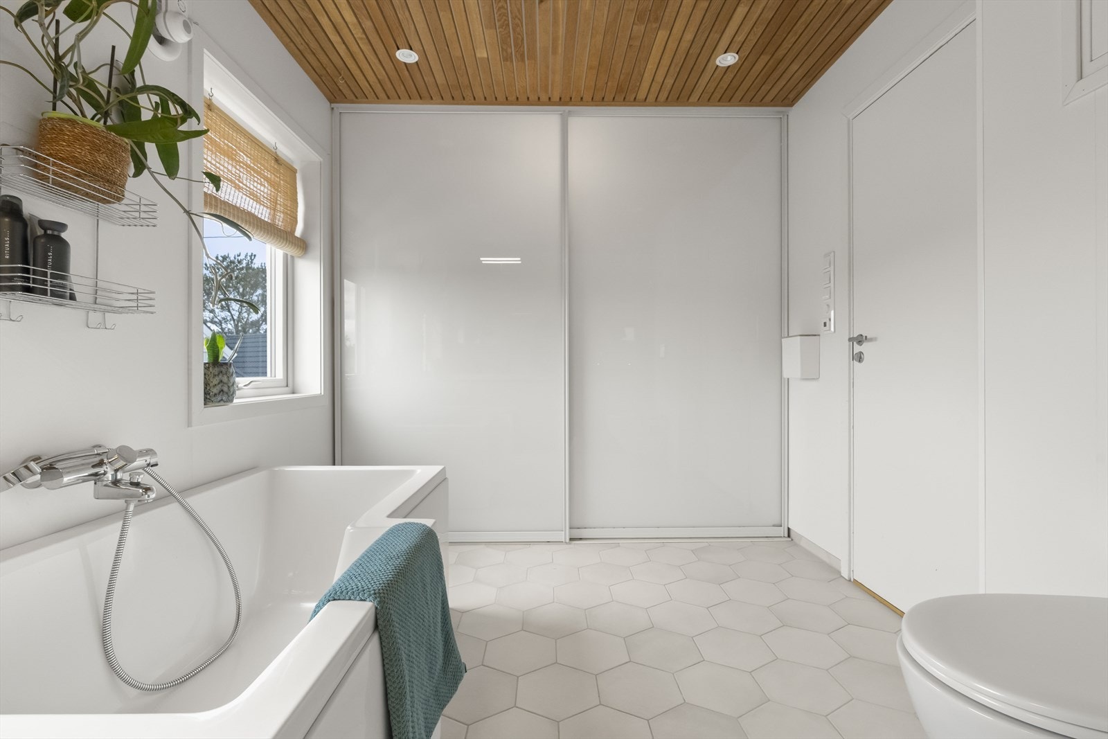 Badet er kombinert vaskerom med praktisk skapplass bak skyvedører. Galleribilde