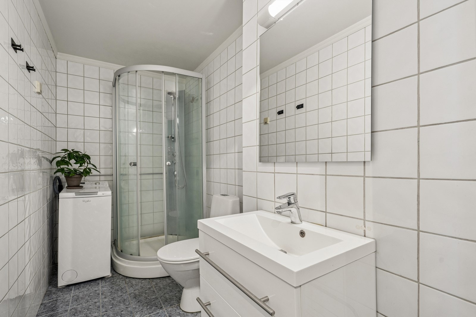 Flislagt bad med elektriske varmekabler i gulvet og opplegg for vaskemaskin. Galleribilde