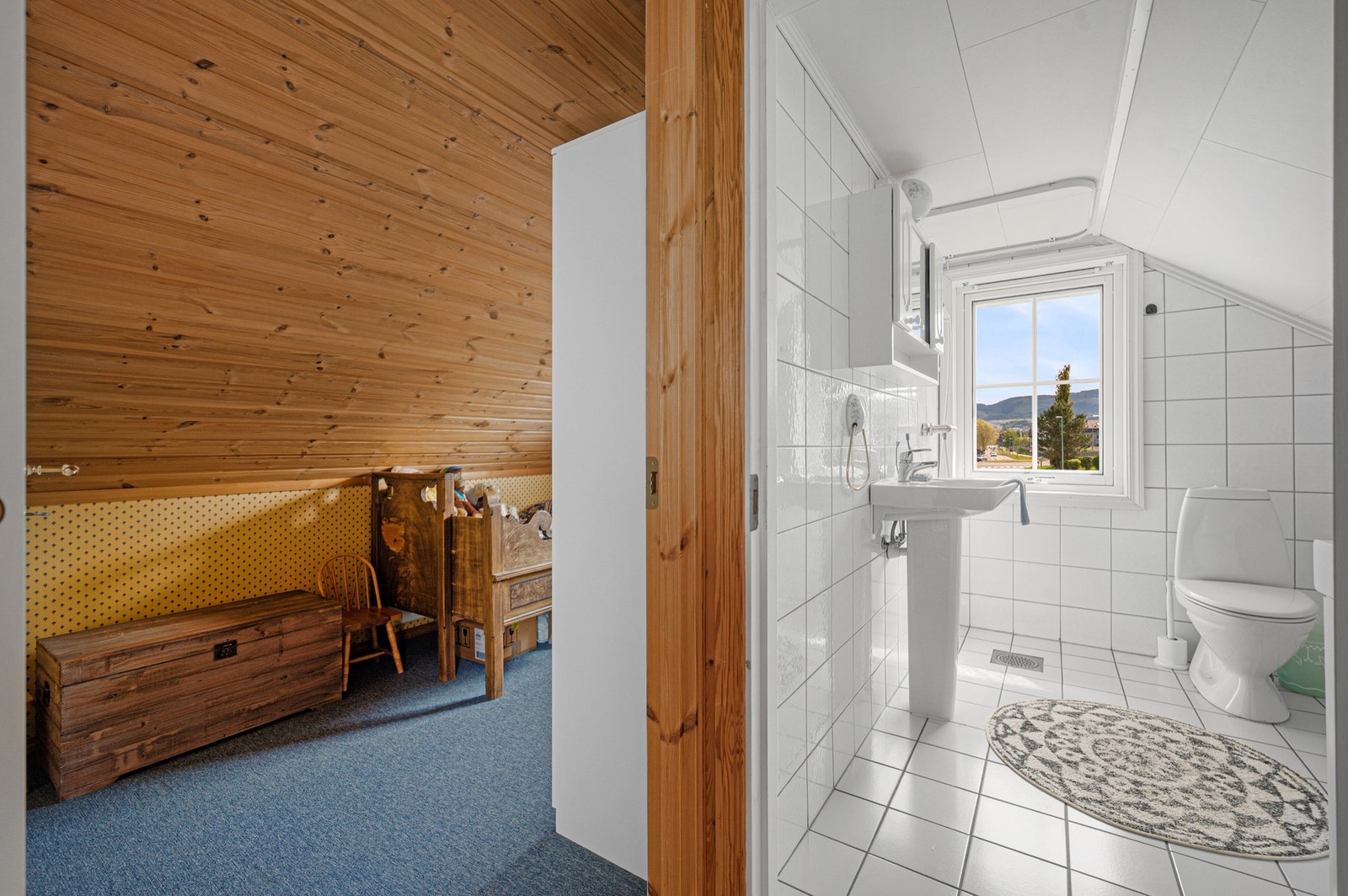 Badet i loftsetasjen har lyse overflater og vindu som gir godt med naturlig lysinnslipp. Galleribilde