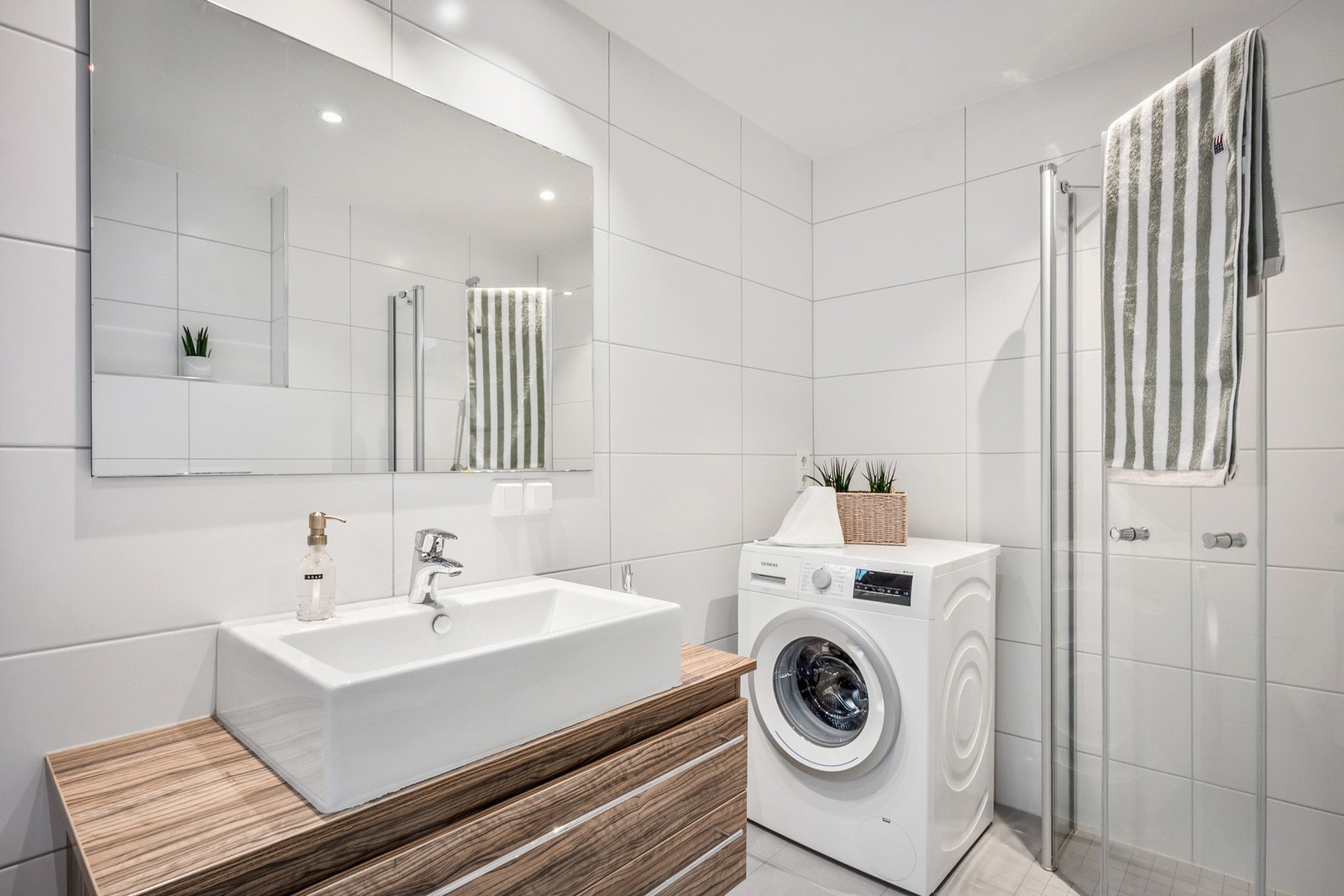Dusjsone med svingbare glassdører og mekanisk ventilasjon. Badet har vannbåren gulvvarme. Galleribilde