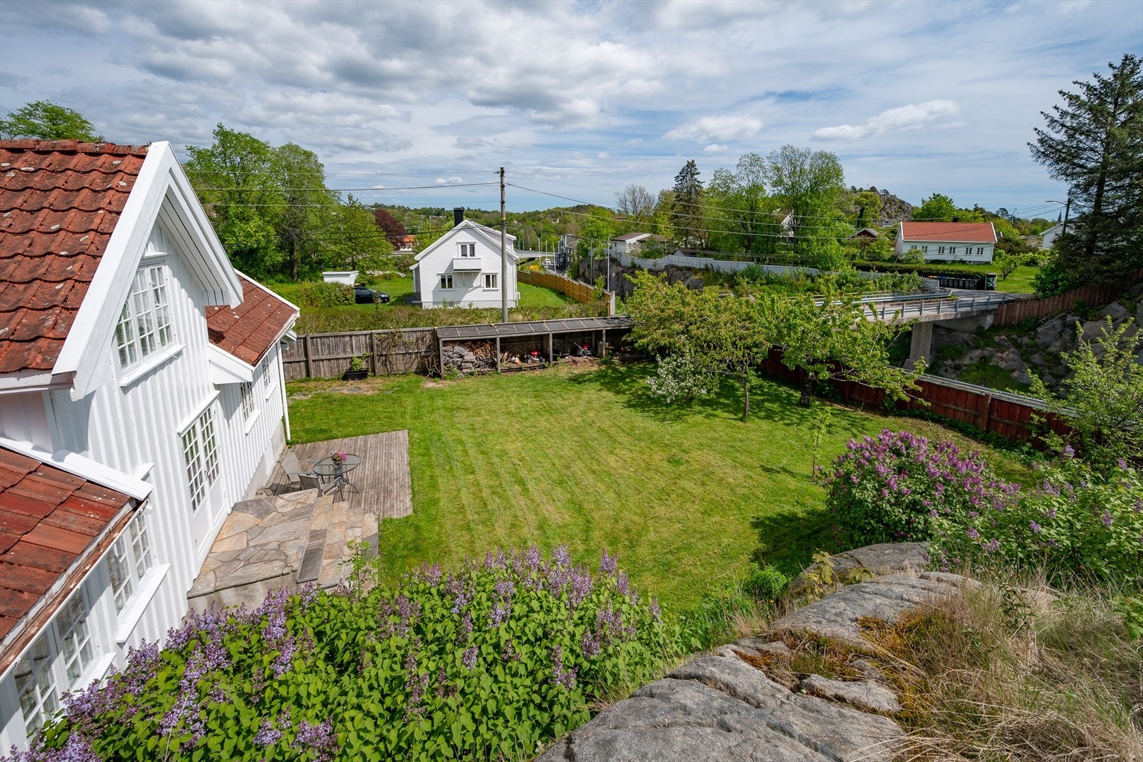 Eiendommen ligger skjermet til med fjellknauser og beplantning. Galleribilde