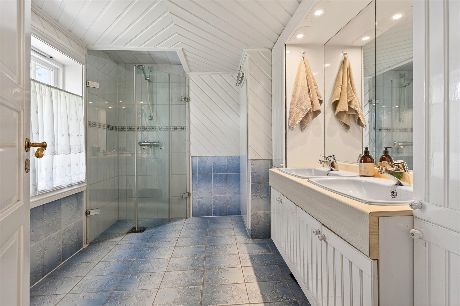 Badet i første etasje er utstyrt med dusjhjørne og en bred innredning med to servanter. Galleribilde