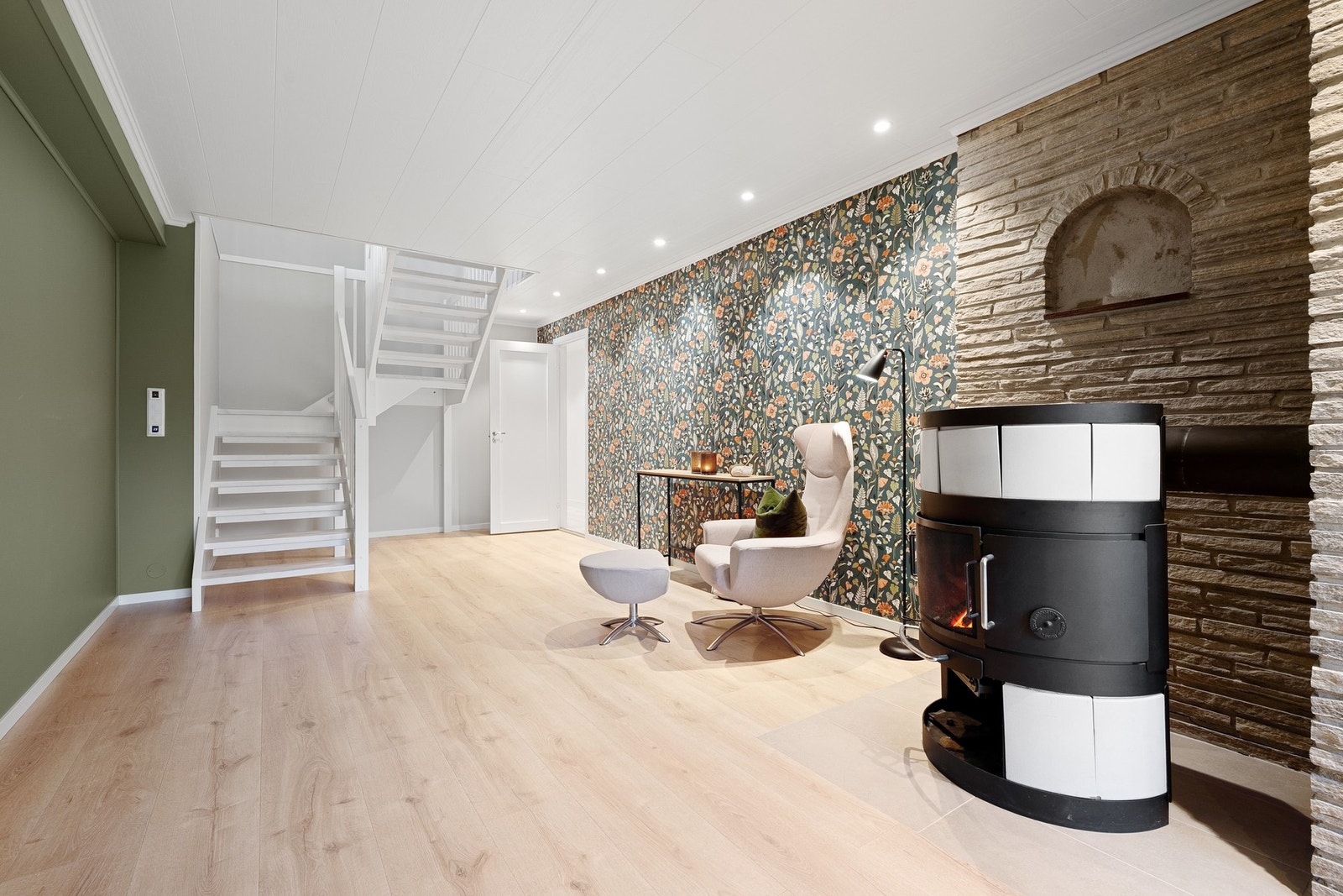 Trappen fra 2018 fører oss ned til kjelleretasjen som byr på et luftig rom med moderne overflater og downlights Galleribilde