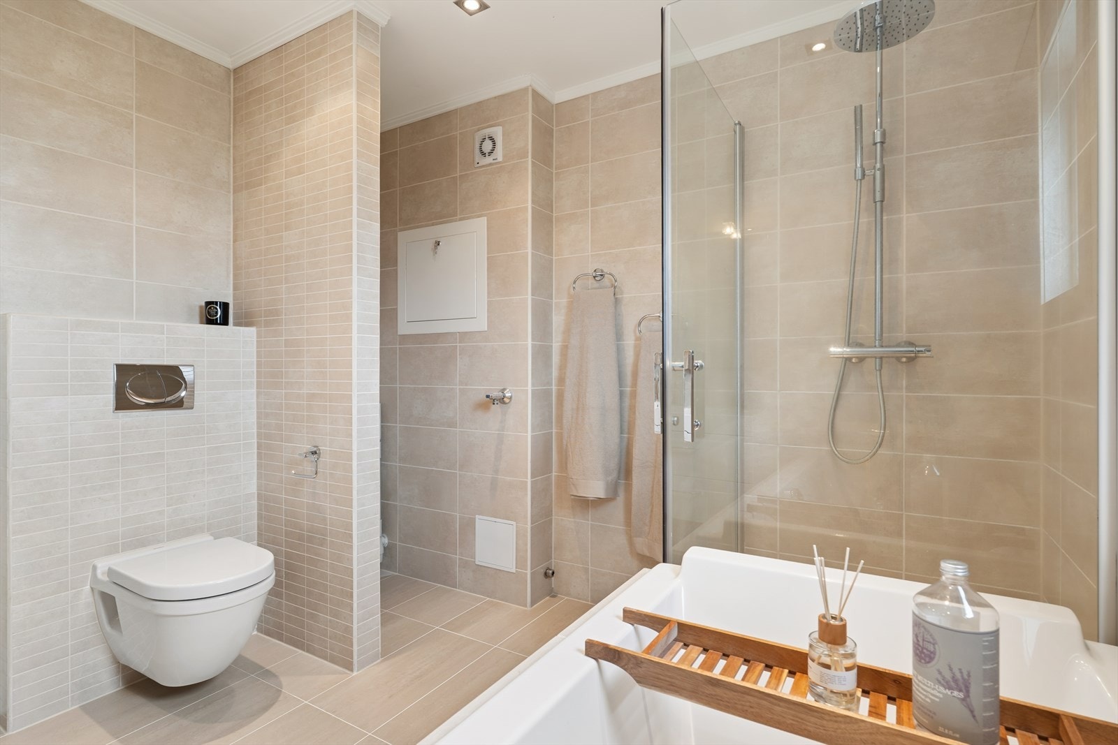 Badet er flislagt og utstyrt med både badekar og dusjkabinett. Galleribilde
