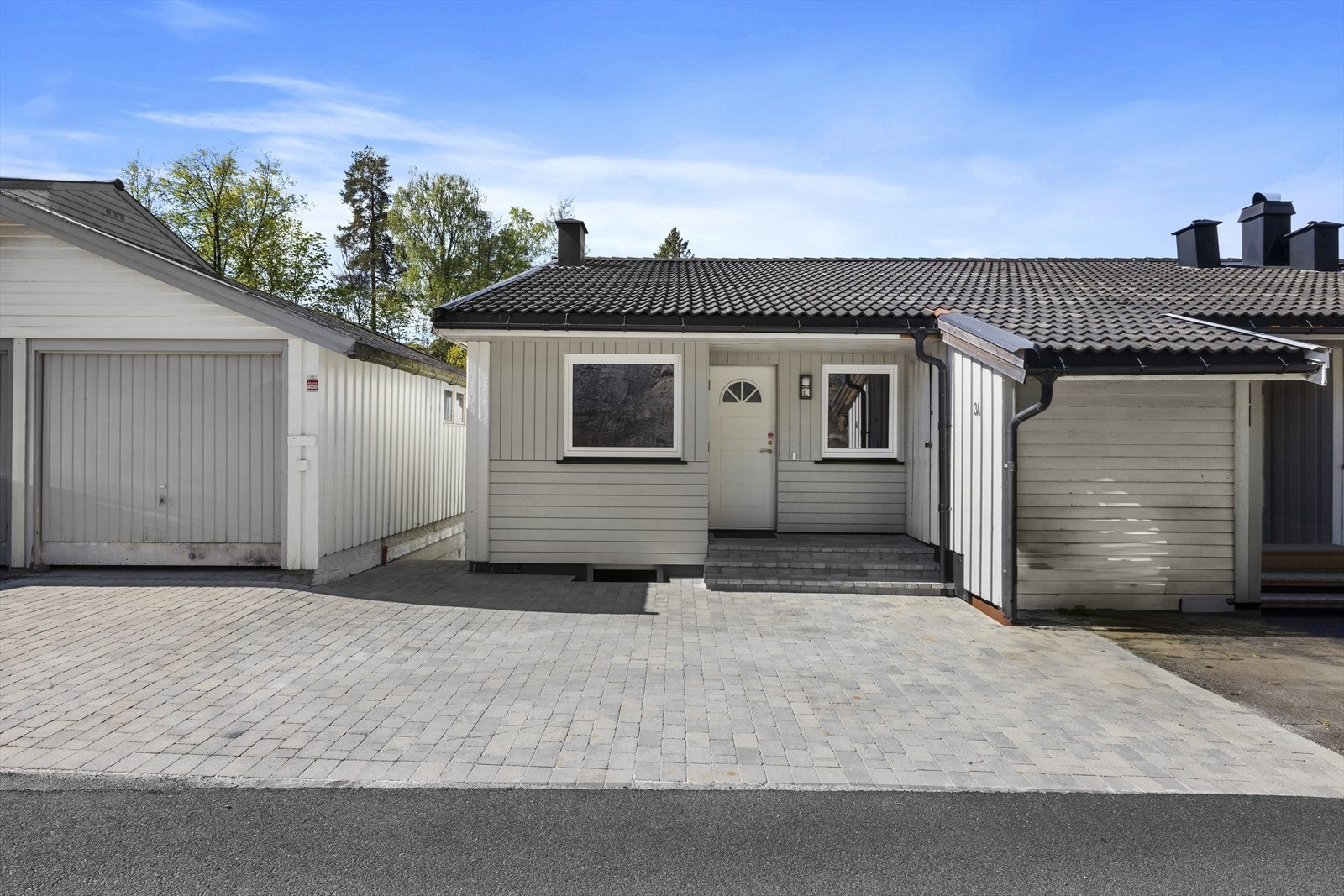 Parkering i halvpart av felles dobbel garasje, og i steinsatt gårdsplass Galleribilde