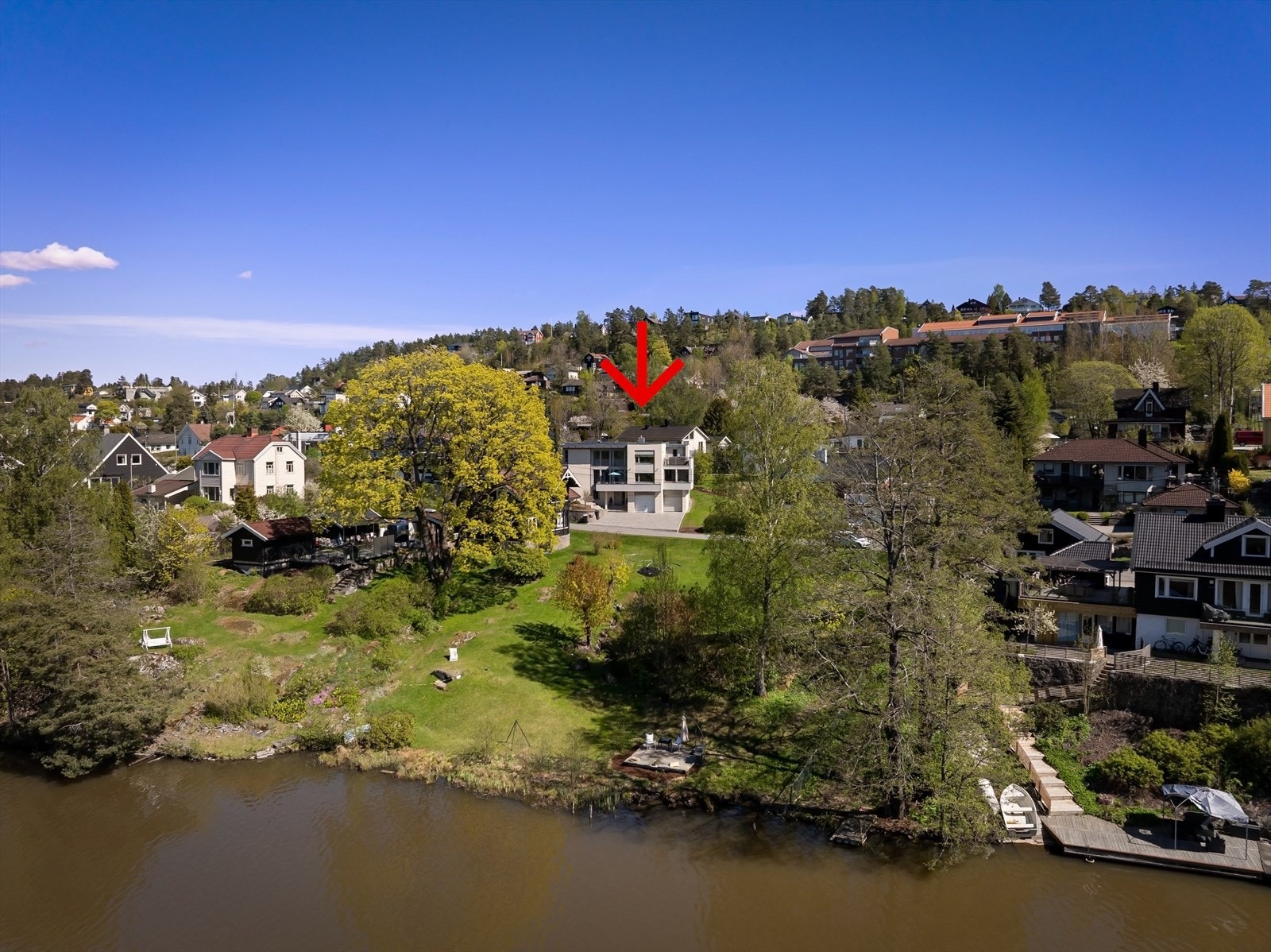 Tomten er fordelt på to parseller - én rundt huset markert med rødt, og én strandparsell nedenfor. Se eiendomskart for nærmere eiendomsgrenser. Galleribilde
