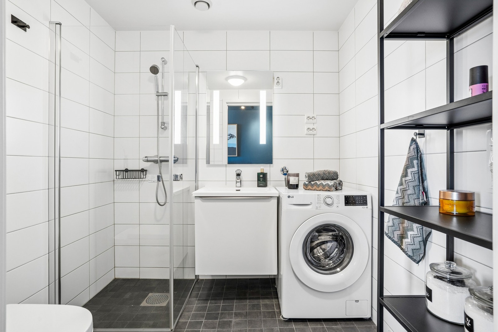 Badet har opplegg for vaskemaskin og servant med underskap for oppbevaring. Galleribilde