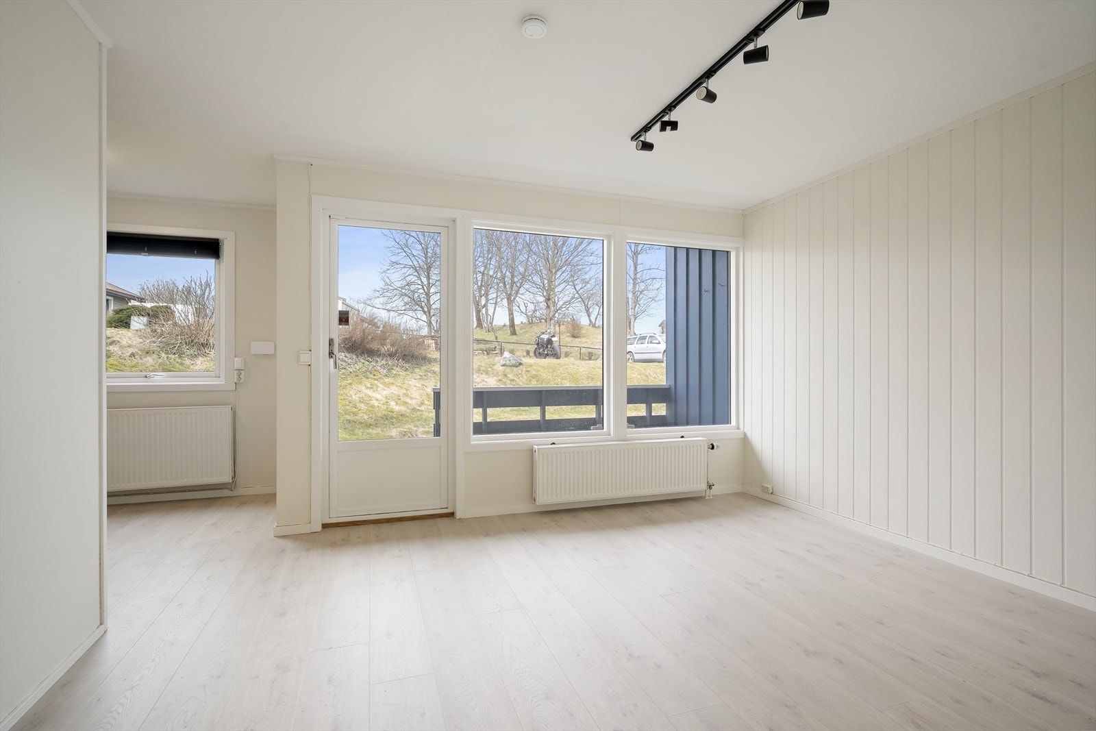 Lys og innbydende stue med store vindusflater som slipper inn rikelig med naturlig lys Galleribilde