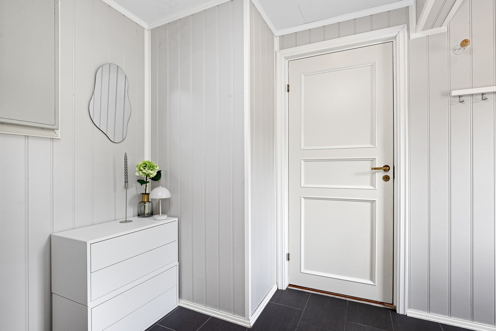 Entré med flislagt gulv og panel på veggene. Innvendig har boligen malte, glatte dører. Galleribilde