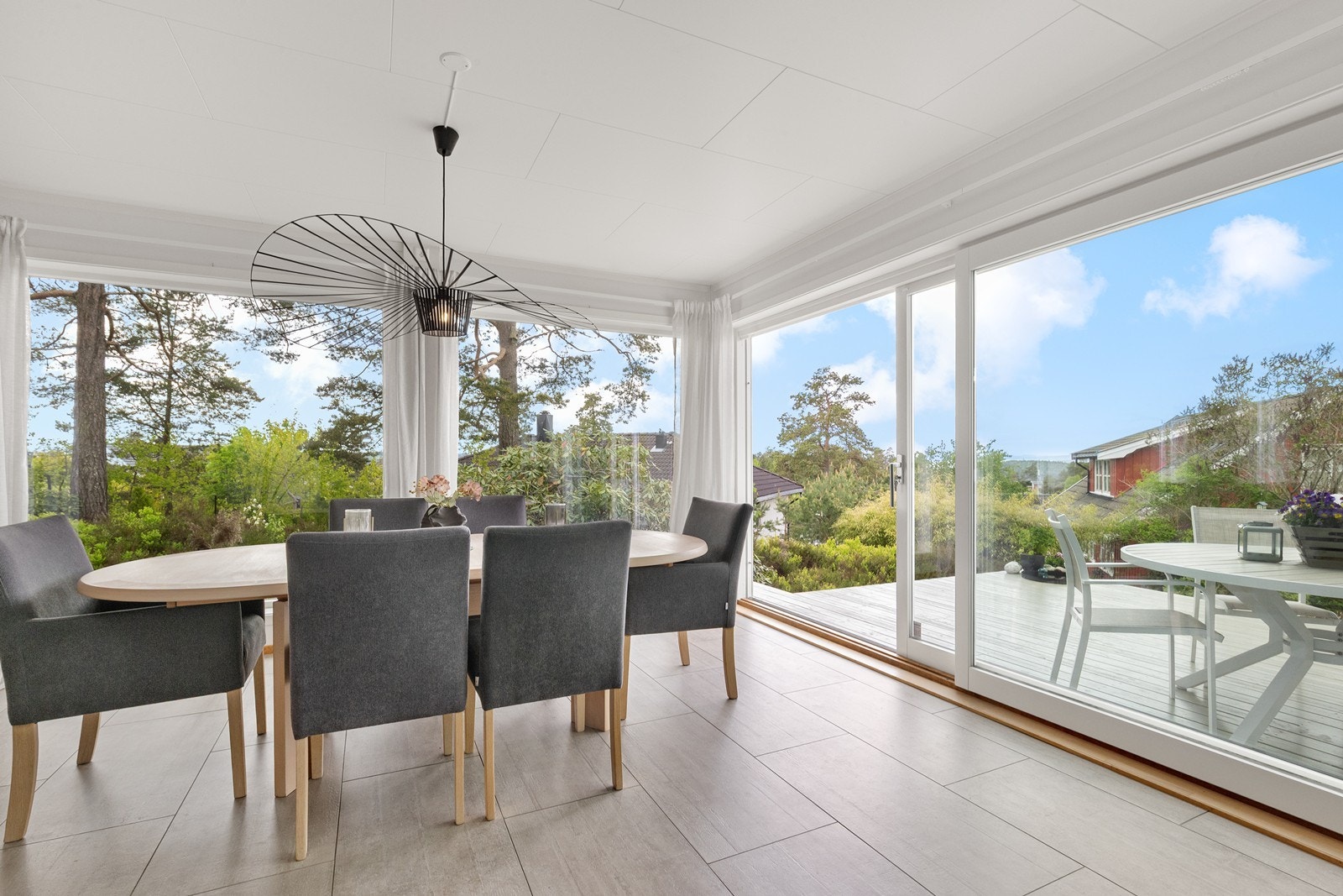 Store skyvedører fra spisestuen åpner opp mot den vestvendte terrassen. Galleribilde