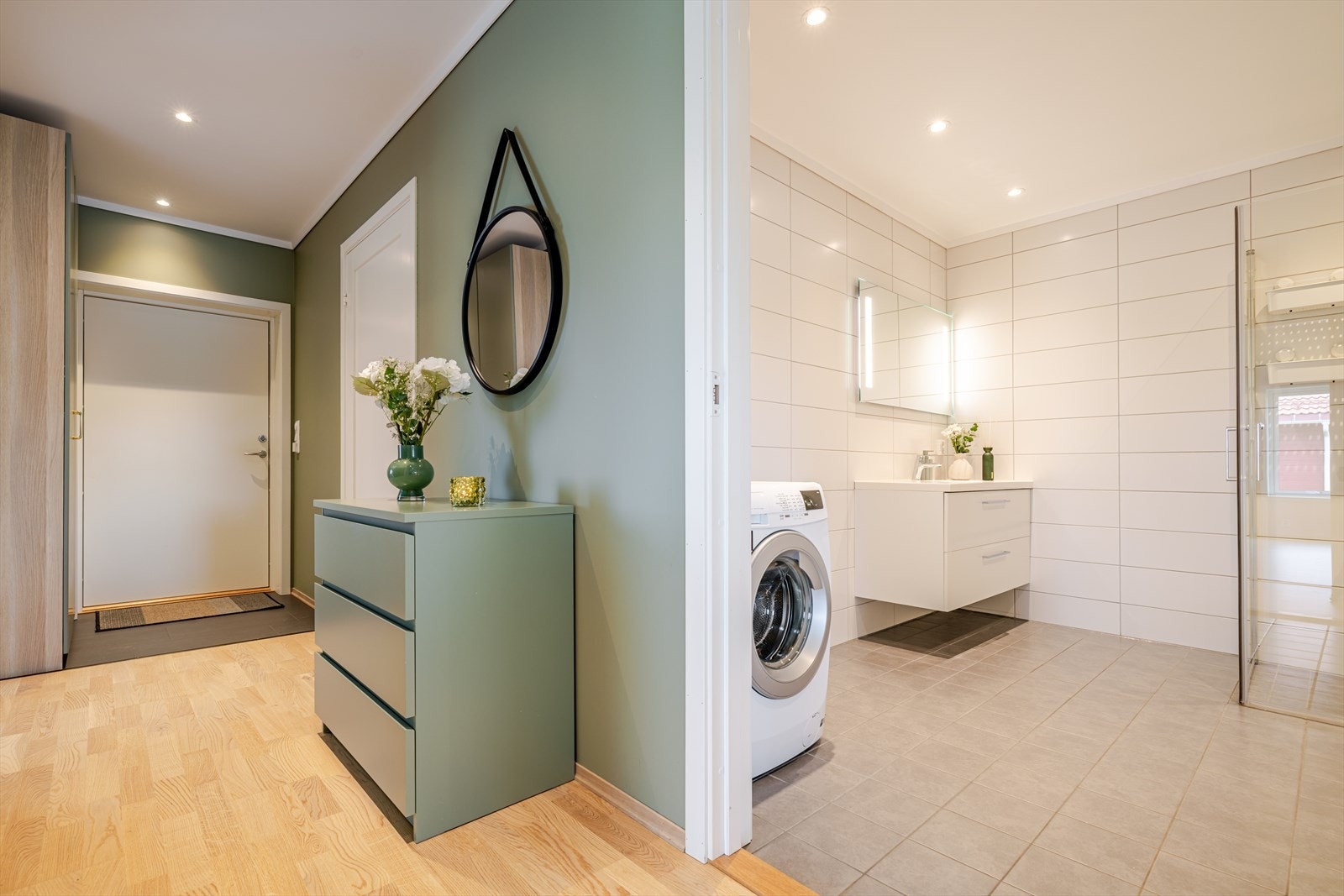 Badet ligger sentralt i leiligheten og er moderne anlagt med flislagte overflater i stilrene fargetoner og behagelig gulvvarme. Galleribilde