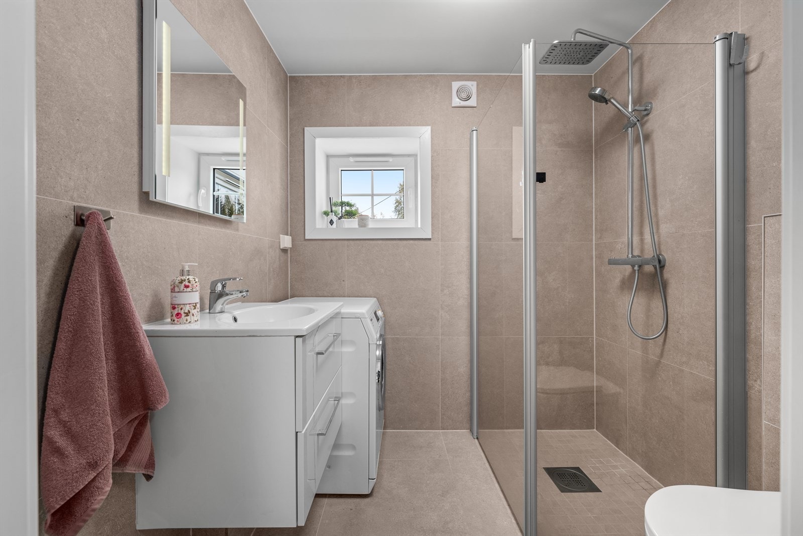 Badet ble pusset opp i 2025 og har keramiske fliser, gulvvarme og opplegg for vaskemaskin. Galleribilde