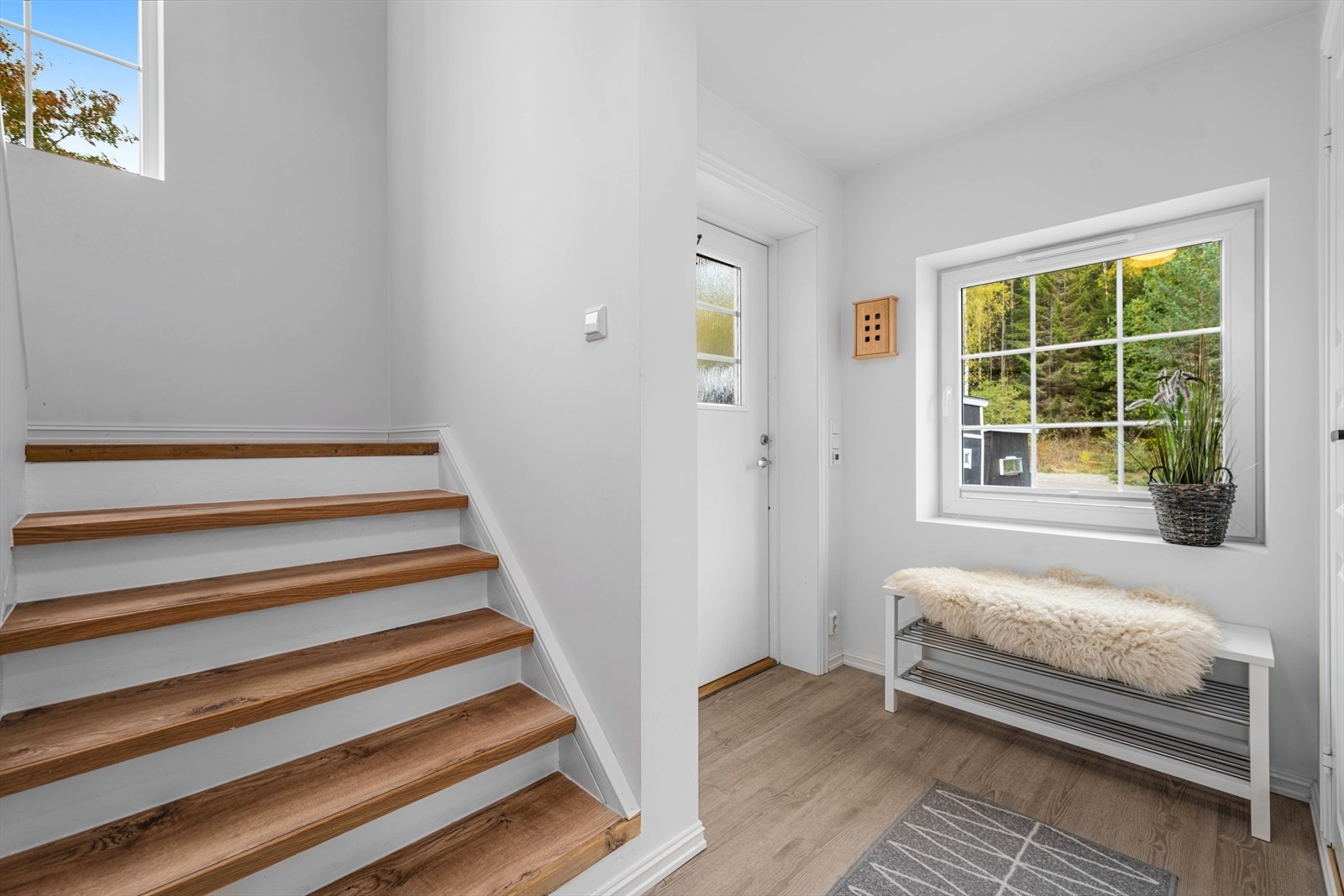 Gangen har laminatgulv og en malt tretrapp med laminat i inntrinnene opp til andre etasje. Galleribilde