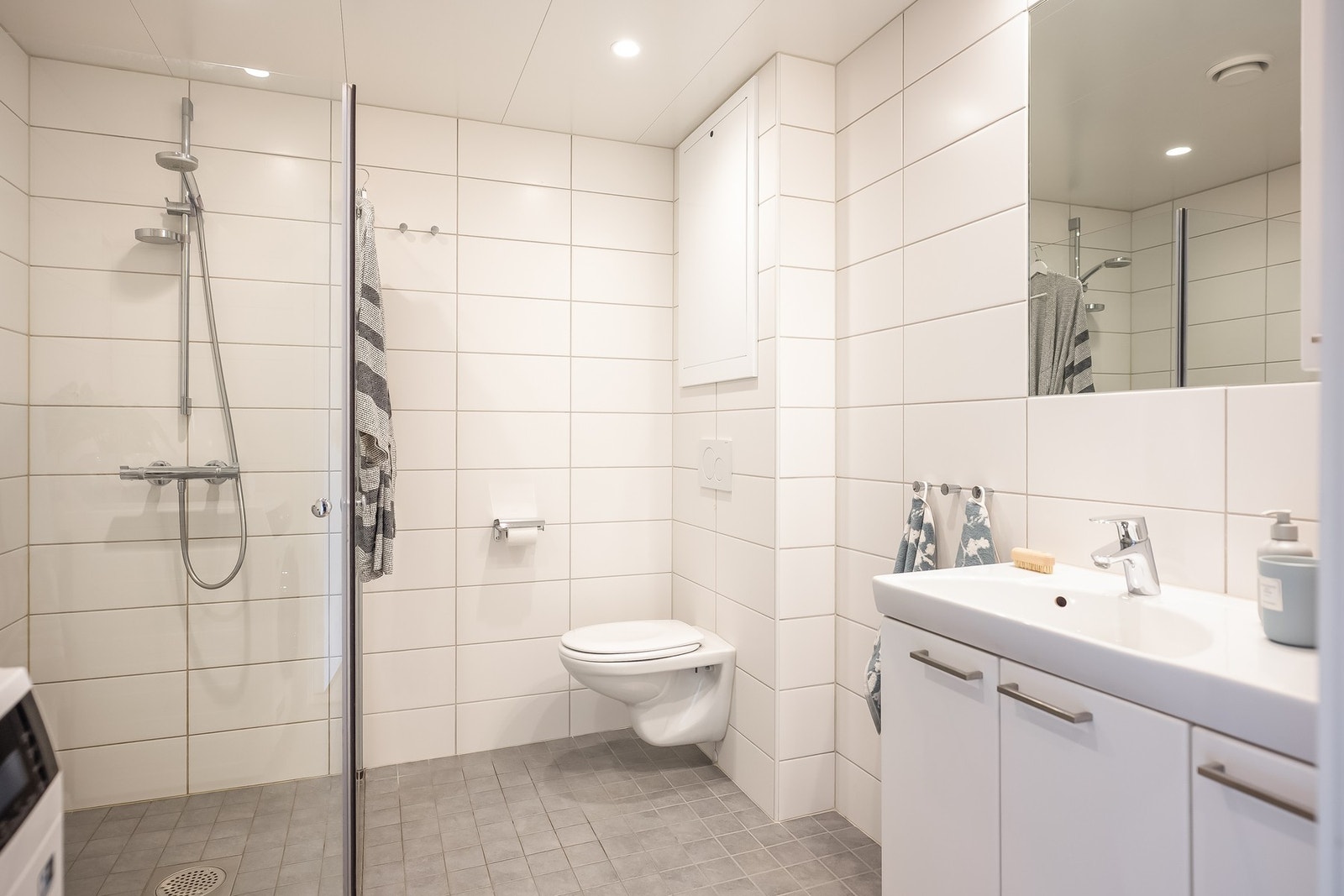 Behagelig oppvarming via varmekabler i gulv, eget opplegg for vaskemaskin, vegghengt toalett, innredning med oppbevaringsplass og romslig dusjnisje med innfellbare glassdører. Galleribilde