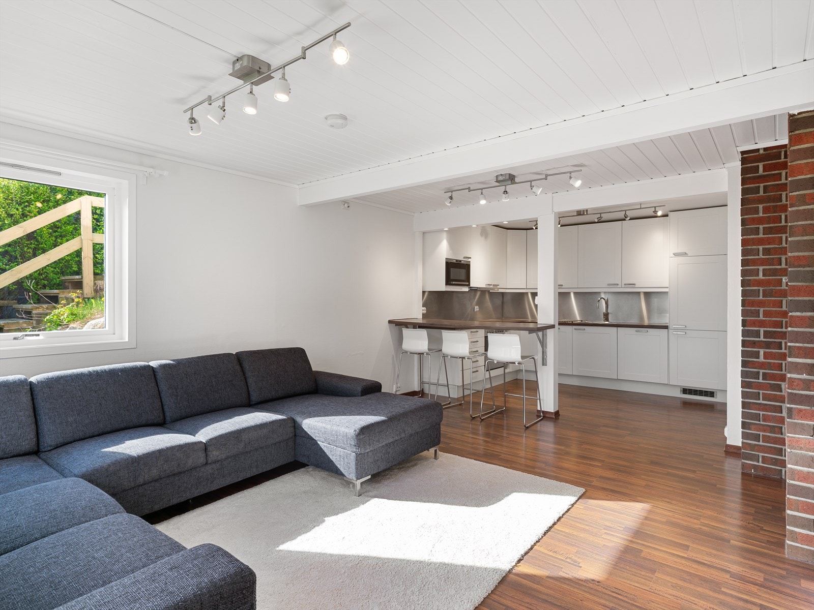 Stuen i leiligheten har en åpen løsning mot kjøkkenet, som skaper et sosialt allrom. Galleribilde