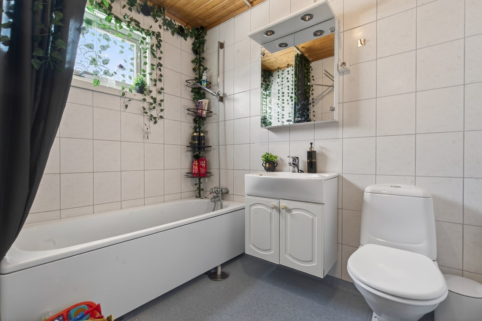 Lyst og innbydende bad med badekar, moderne servantløsning og praktisk oppbevaring. Perfekt for avslapning og velvære. Galleribilde