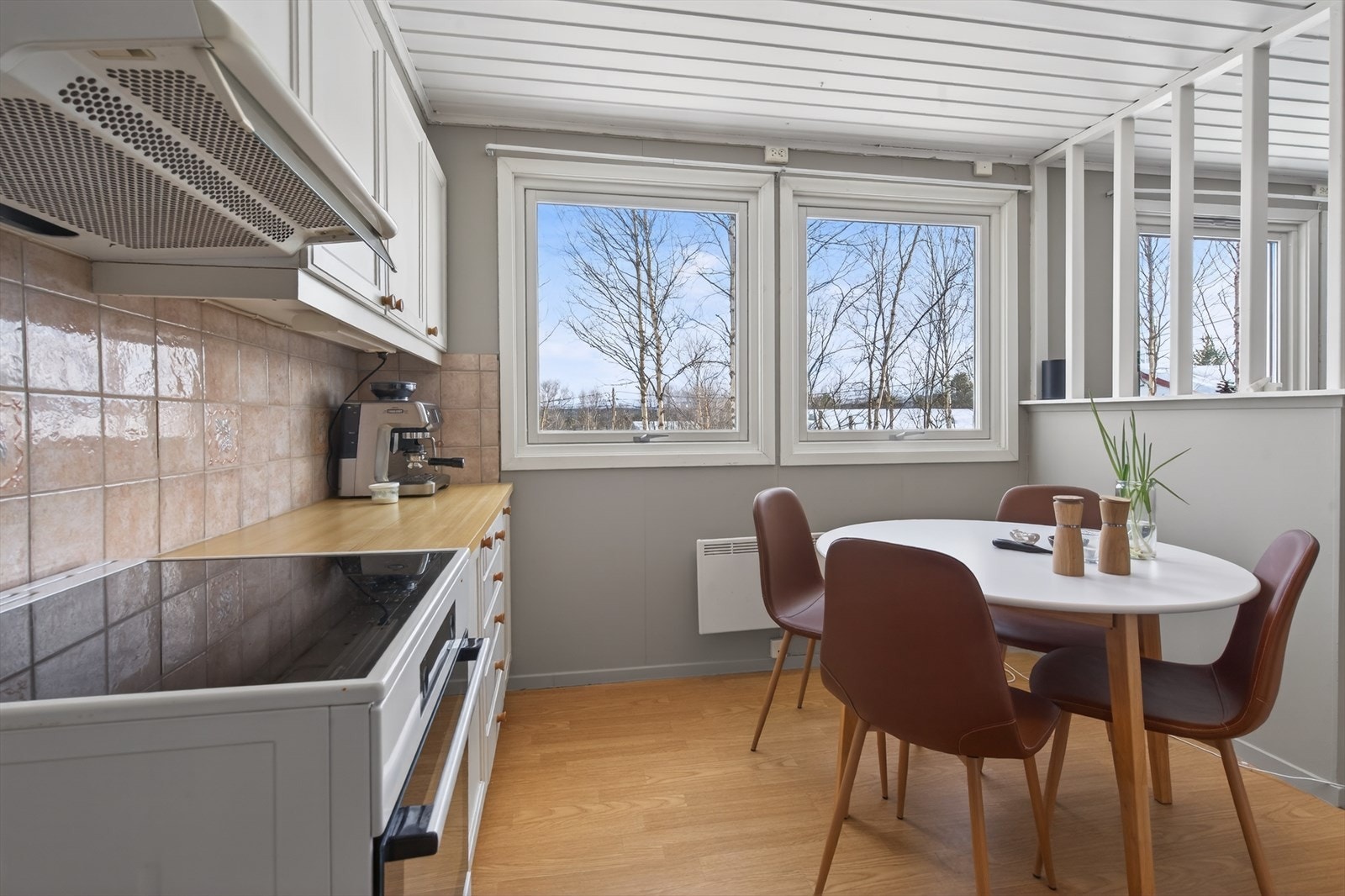 Lyst kjøkken med store vinduer som gir flott utsikt mot naturen utenfor. Perfekt for koselige måltider med utsikt. Galleribilde