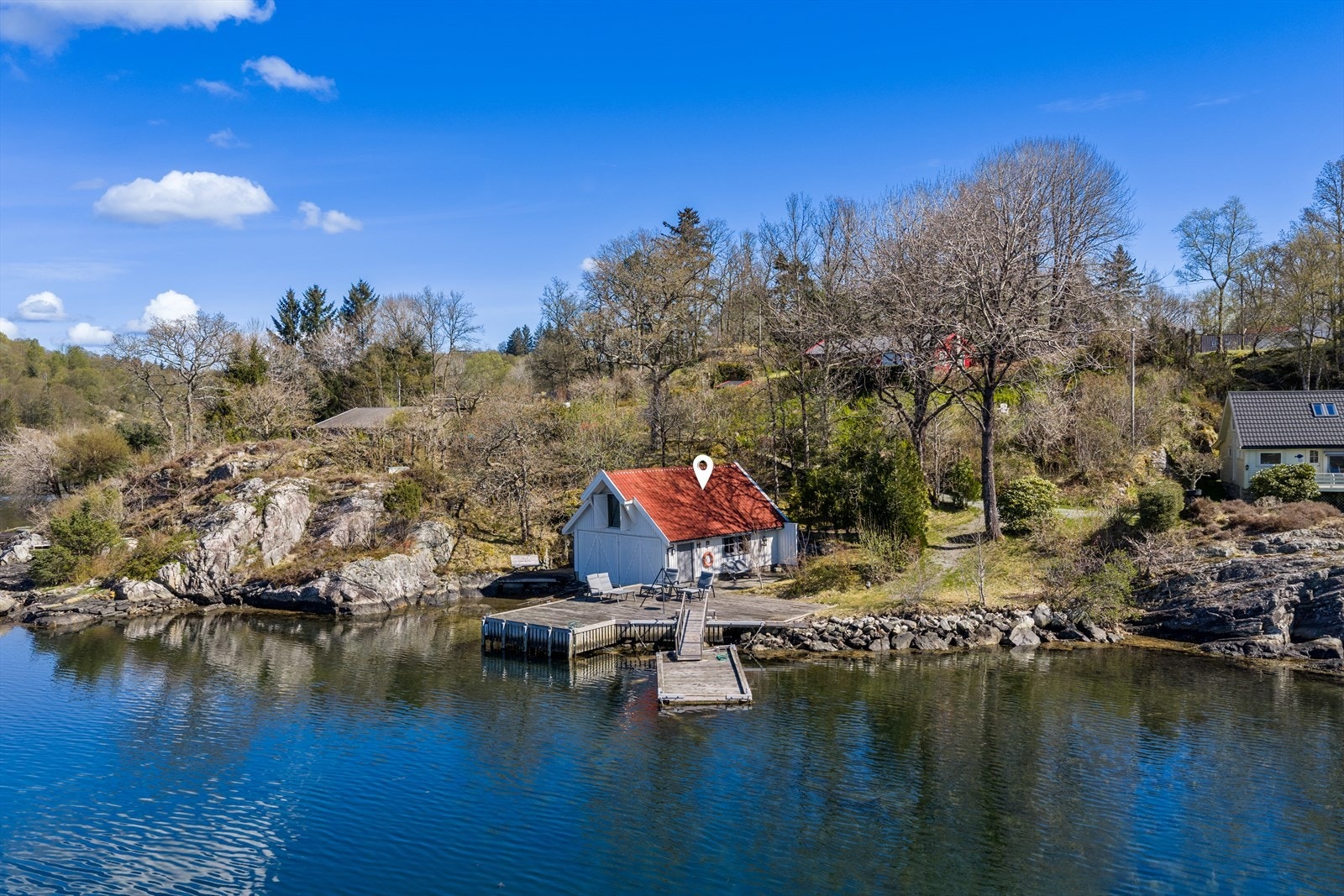 Tilhørende naust ligger idyllisk til ved vannkanten. Galleribilde