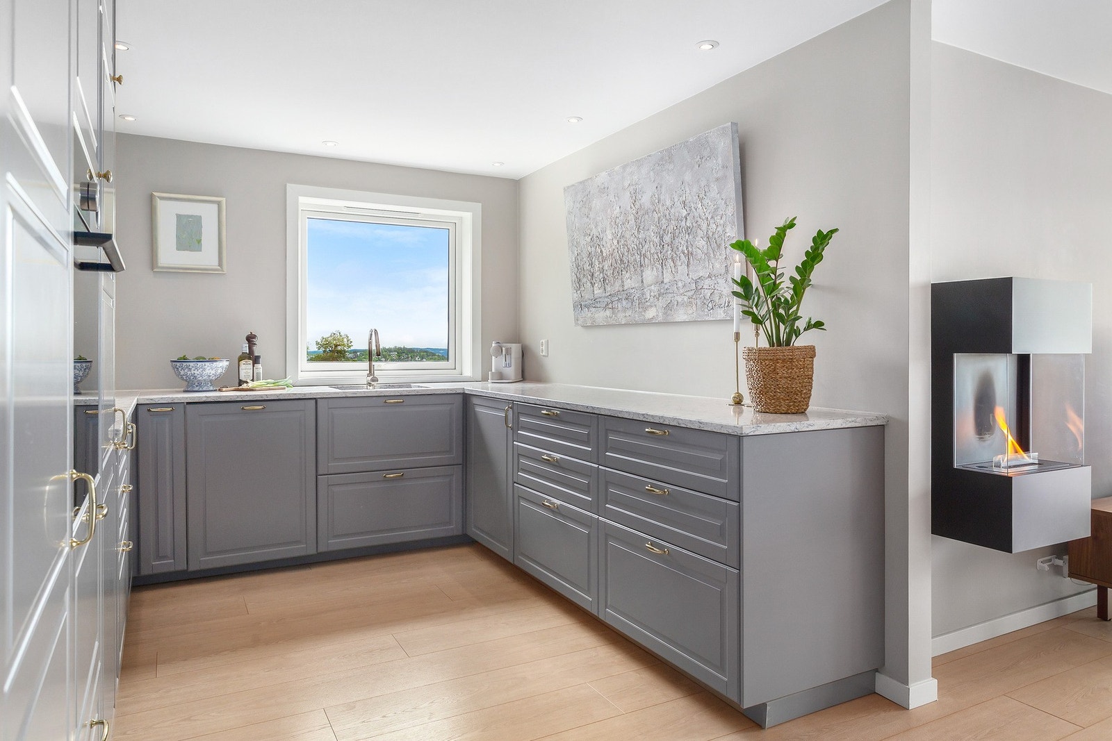Kjøkkenet har en moderne og åpen løsning med IKEA-innredning fra 2019, benkeplate i stein, samt profilerte fronter som gir et tidløst uttrykk. Galleribilde