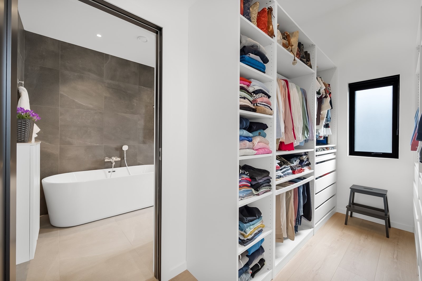 Walk-in closet med praktisk løsning for oppbevaring, rett ved badet. Galleribilde