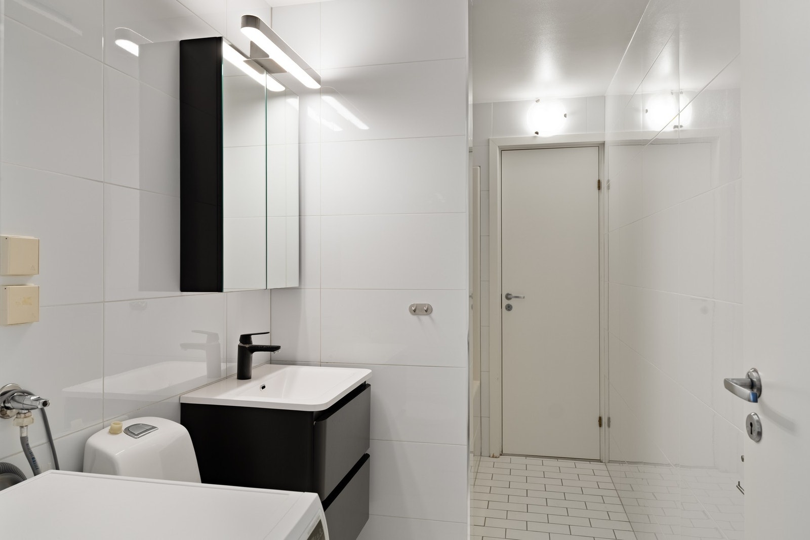 Pent, flislagt bad med opplegg for vaskemaskin. Galleribilde
