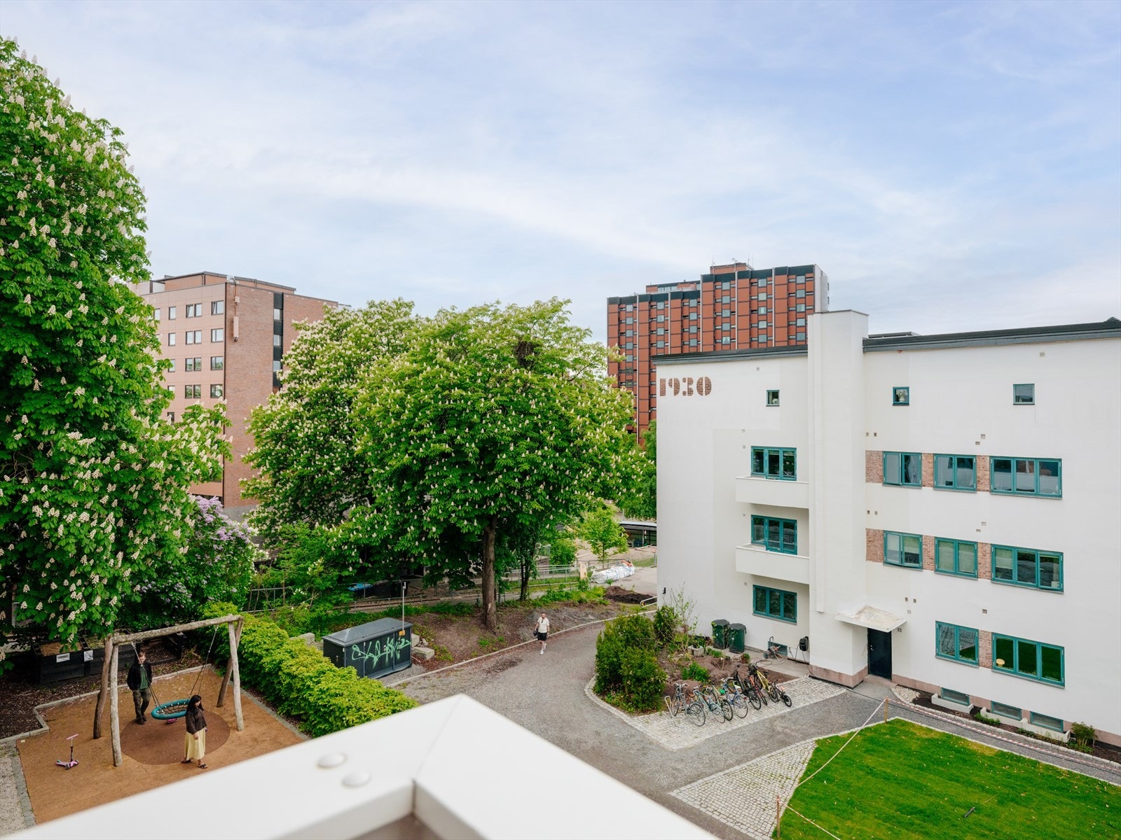Utsikt fra balkongen mot det frodige og velholdte gårdsrommet i populære Funkisgården. Galleribilde
