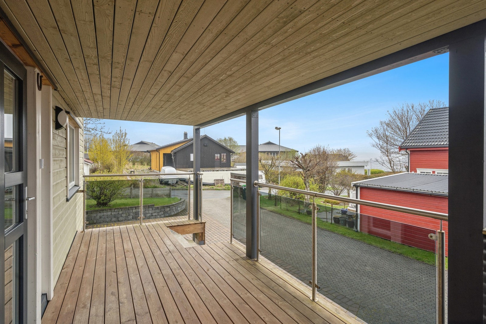 Overbygget terrasse ved inngangspartiet. Totalt har eiendommen fire uteplasser fordelt på to etasjer. Galleribilde