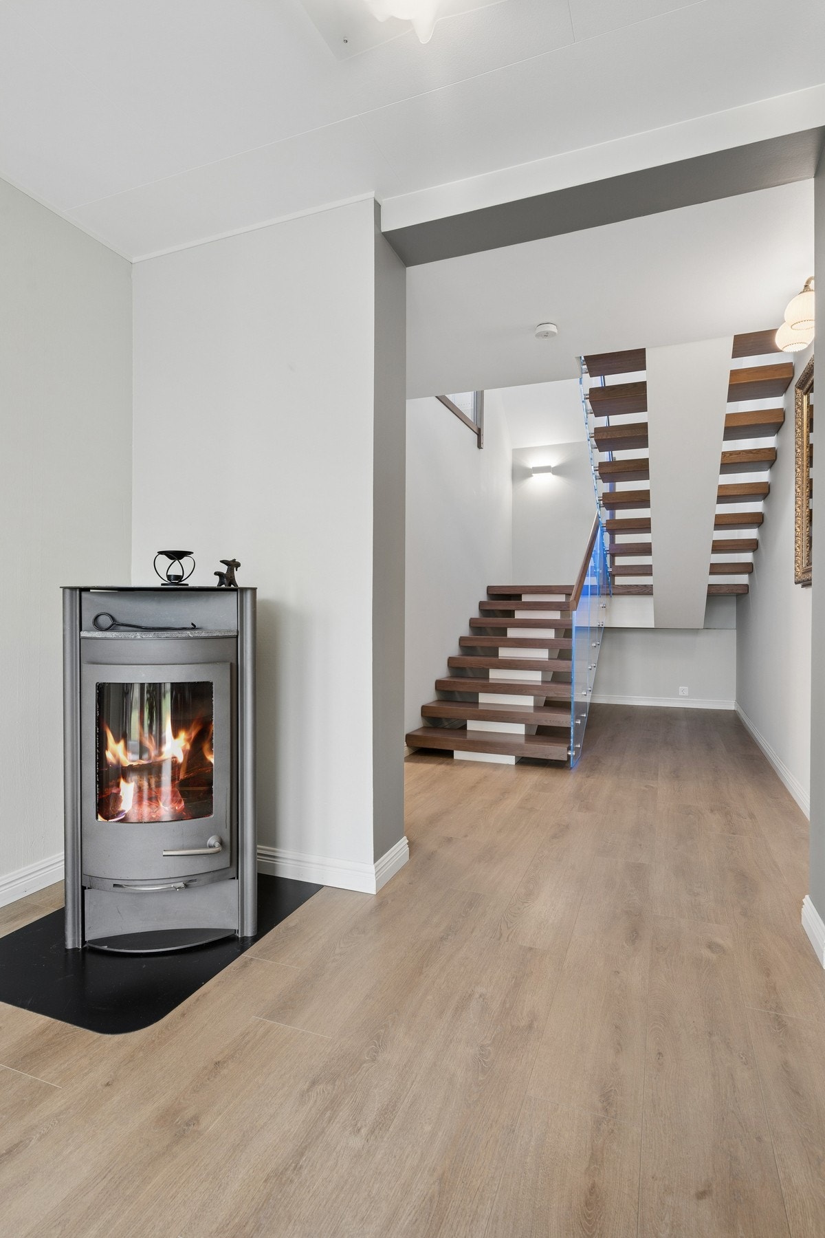 Tretrappen med glassrekkverk leder opp til andre etasje. Galleribilde