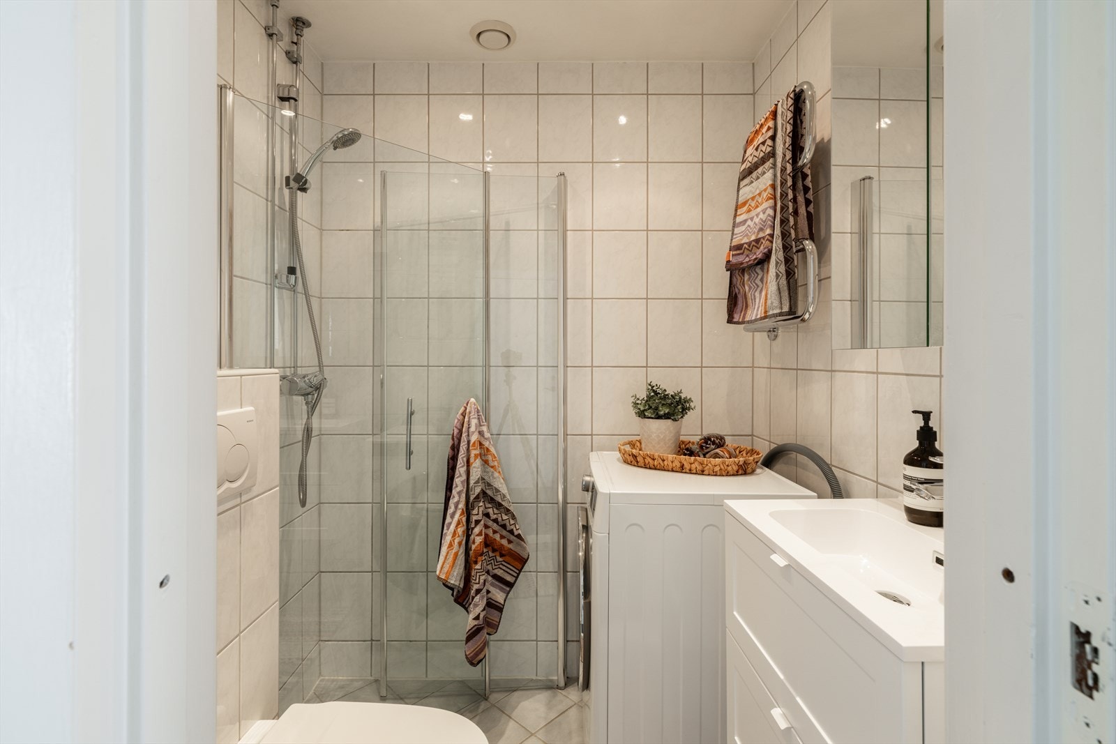 Badet har flislagte gulv, flislagte vegger, malte plater i tak og varmekabler i gulv. Galleribilde