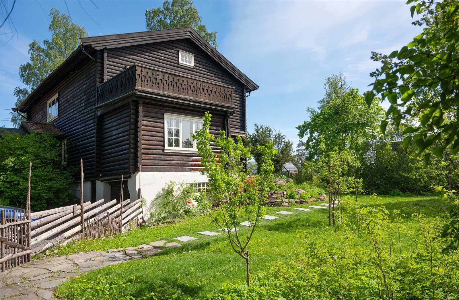 Tomten er opparbeidet med gressplen og heller. Galleribilde