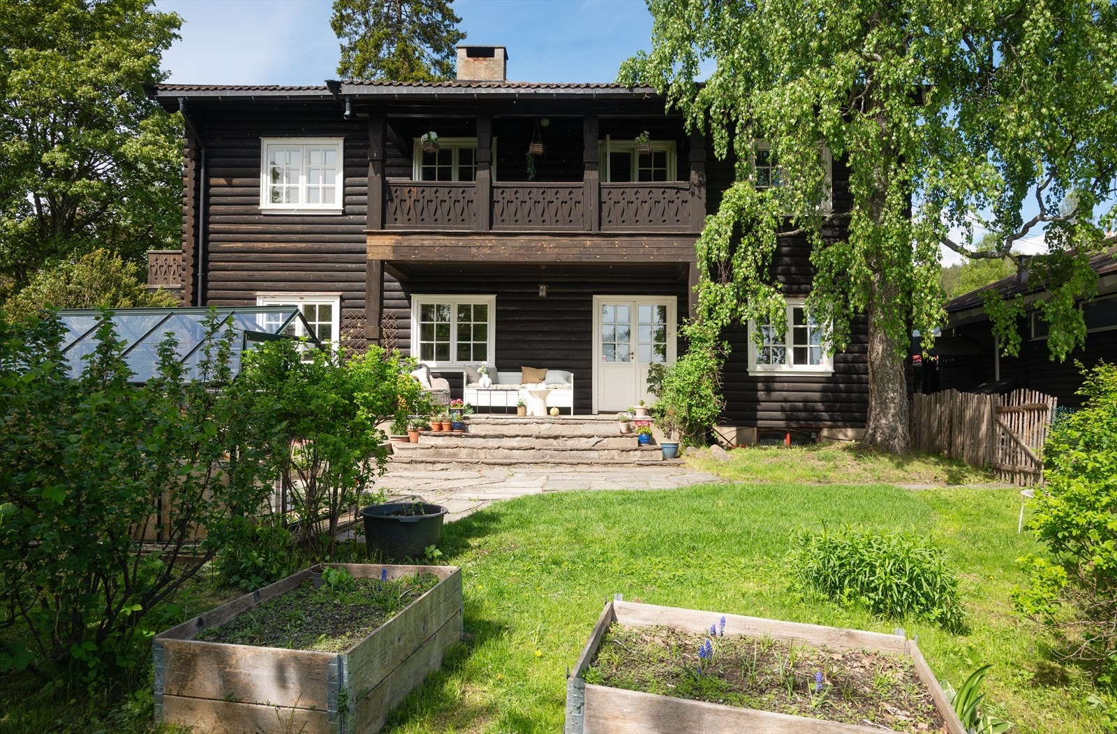Hagen er opparbeidet med plen, beplantning og dyrkingskasser. Galleribilde