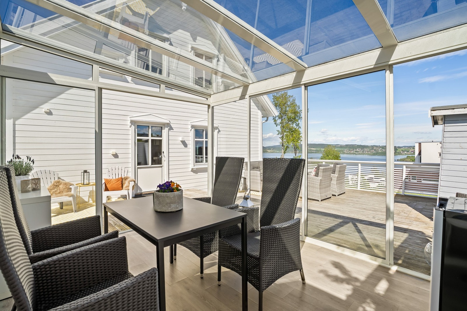 En lys og innbydende vinterhage som forlenger utesesongen og gir en lun plass for både måltider og avslapning. Galleribilde