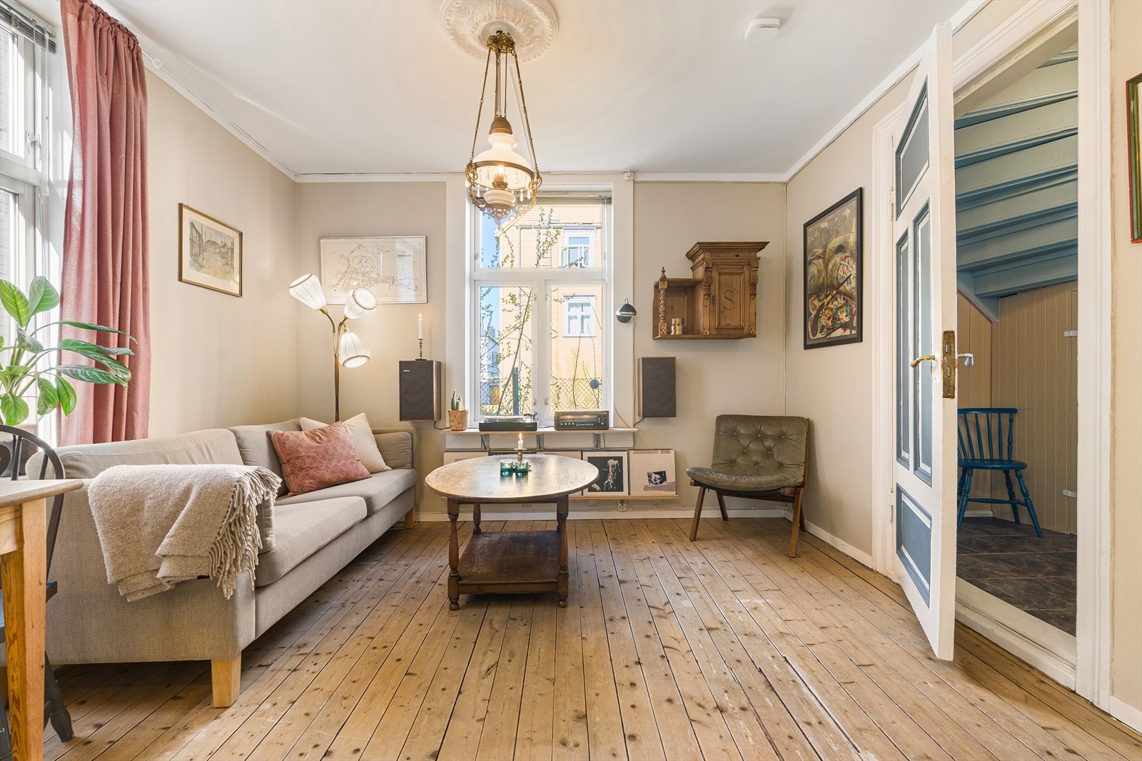 Naturlig dagslys fra de store vindusflatene skaper en lun og god atmosfære. Vegger på stue er malt i den behagelige fargen "soothing beige" som harmoniserer med klassiske hvite karmer og dører. Galleribilde
