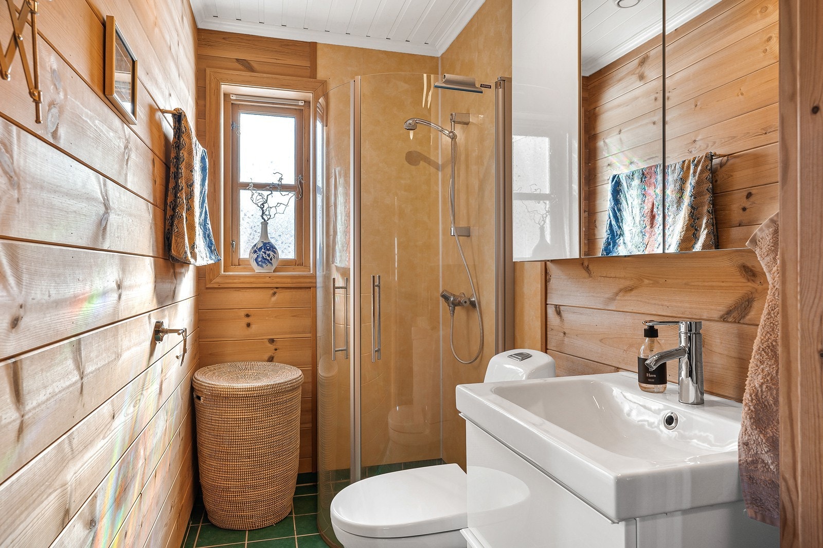 Badet er innredet med dusjsone med glassvegger og garnityr, innredning med heldekkende servant og blandebatteri, samt gulvstående toalett ( byttet i 2017) Galleribilde