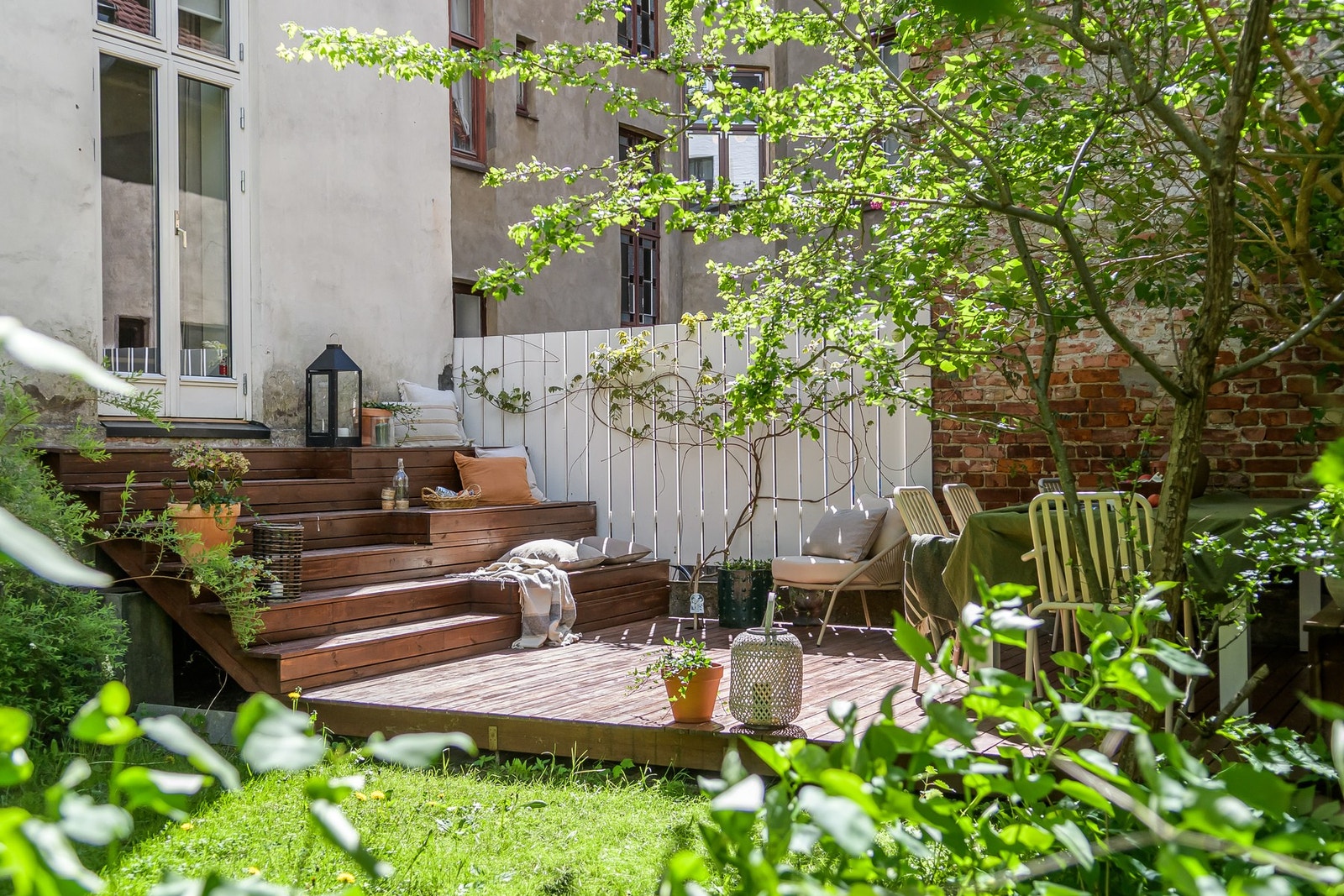 Leiligheten har et særdeles hyggelig uteområde med direkte utgang fra spisestue til en skjermet terrasseplatting og grønn felles bakhage Galleribilde