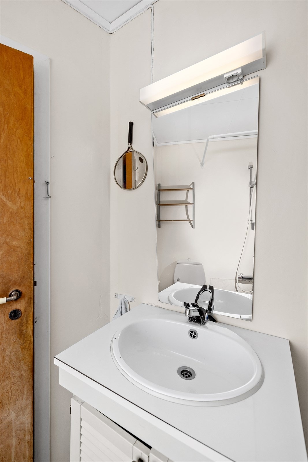 Badet er utstyrt med dusj på vegg med dusjforheng, toalett og godt med skapplass i innreiinga. Galleribilde
