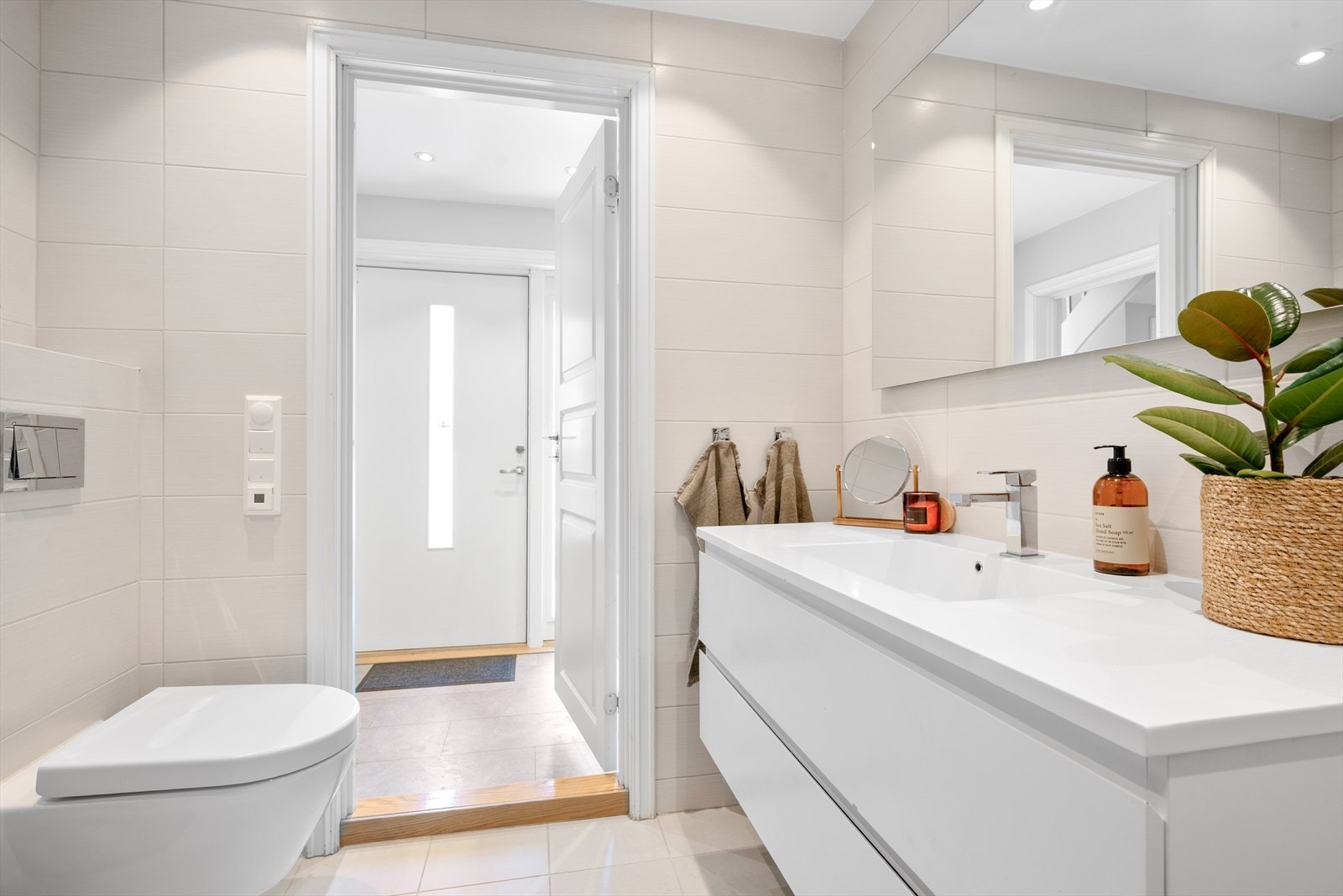 Badet er utstyrt med vegghengt toalett og en romslig innredning med nedfelt servant og skuffer. Det er oppbevaringsmuligheter både i skuffene på innredningen og høyskap. Galleribilde