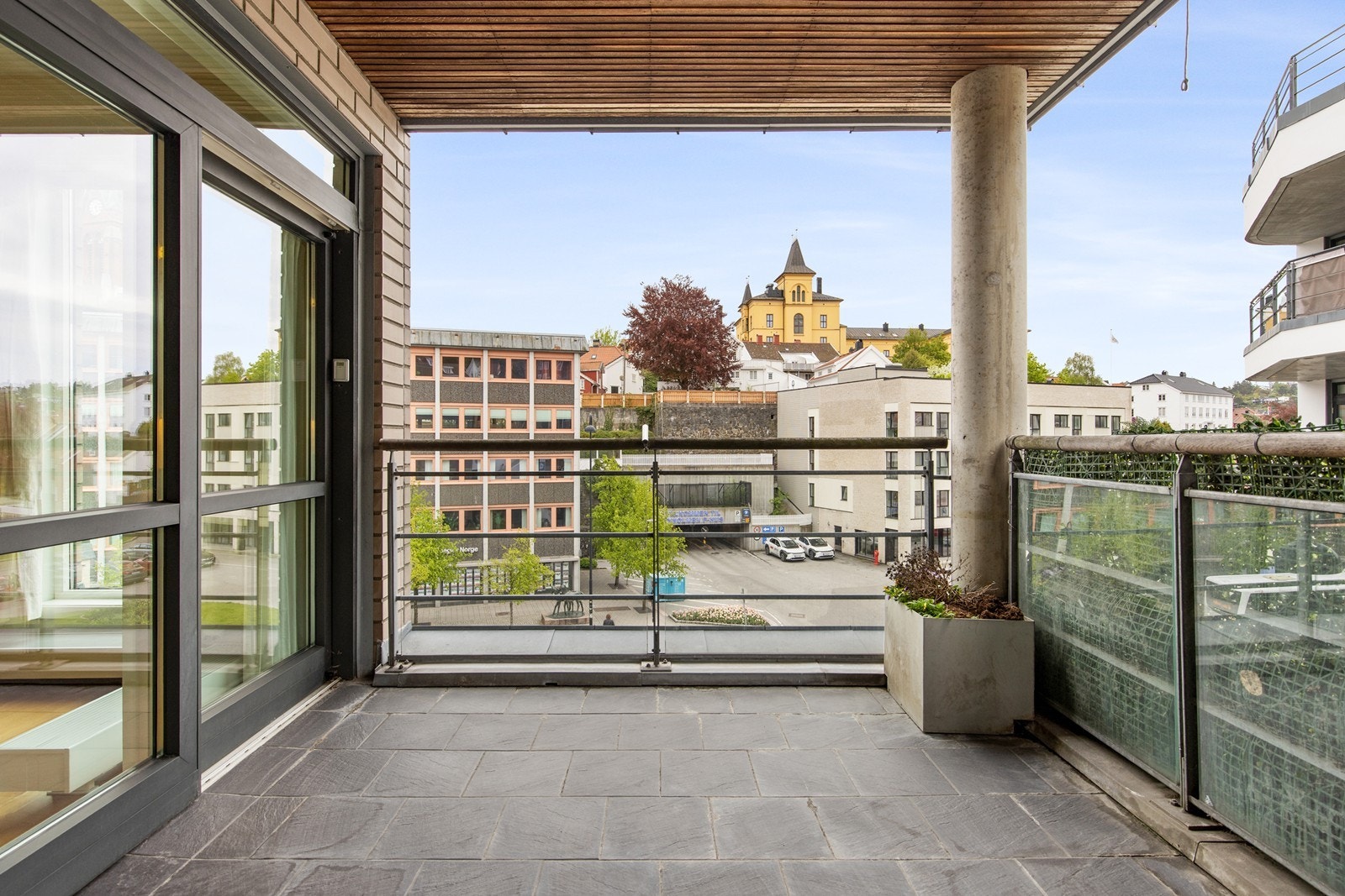 Romslig overbygd balkong med god plass til hagemøblement Galleribilde