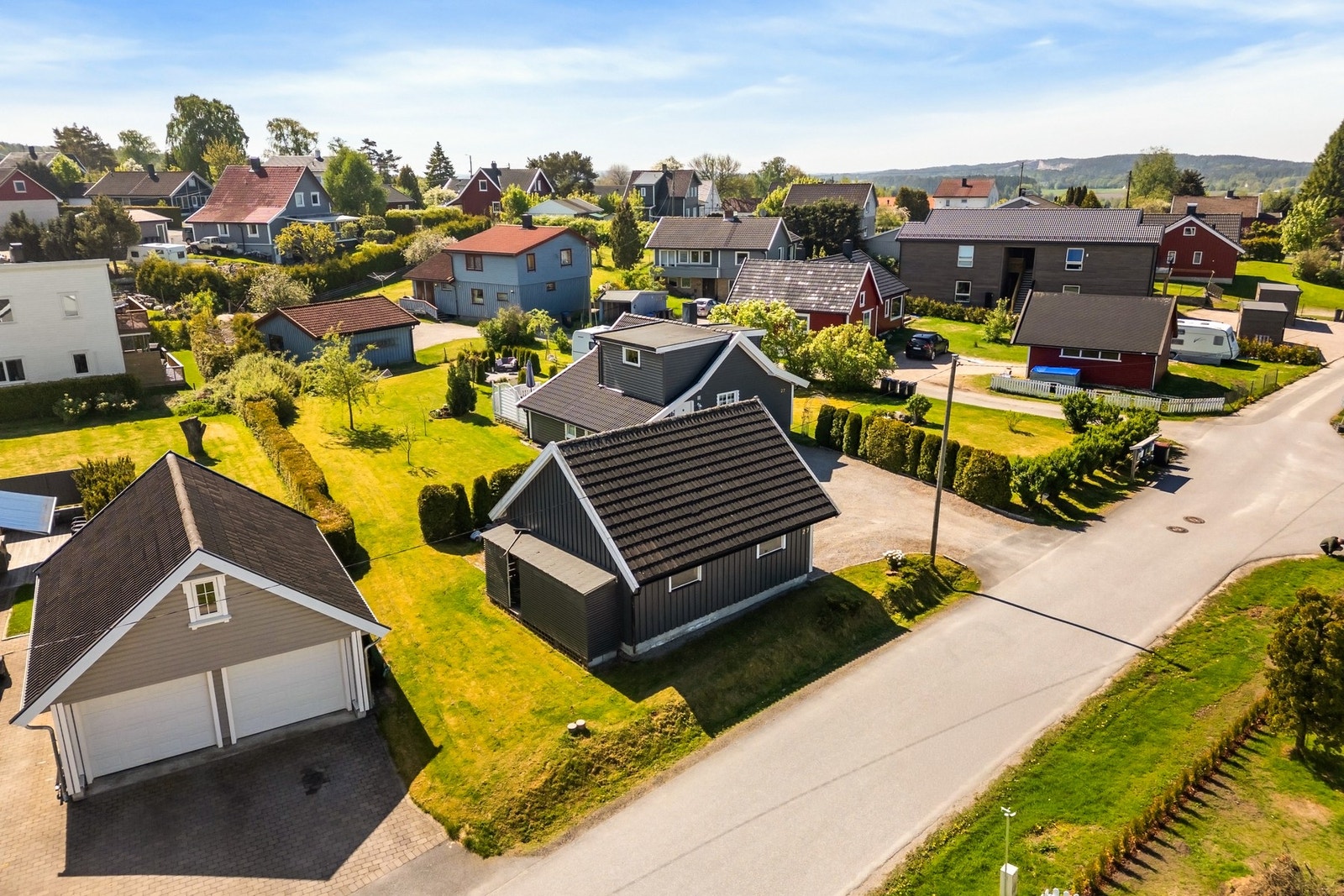 Tomten er delvis inngjerdet, og resten er pent innrammet med diverse hekkbeplantning. Galleribilde