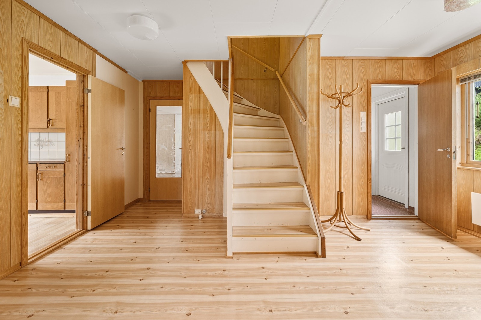 Romslig hall med tilknytning til flere av boligens rom. Galleribilde