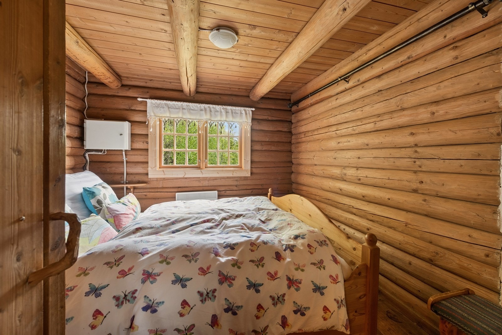 Soverommet i hovedhytta har plass til dobbeltseng. En hjemmelaget paneldør er en fin detalj. Galleribilde