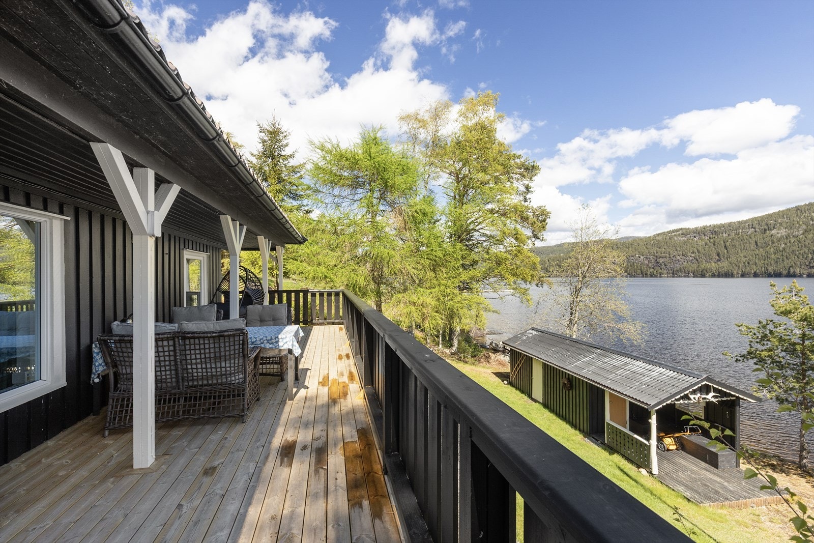 Den delvis overbygde terrassen i trekonstruksjon har god plass til en sittegruppe. Galleribilde