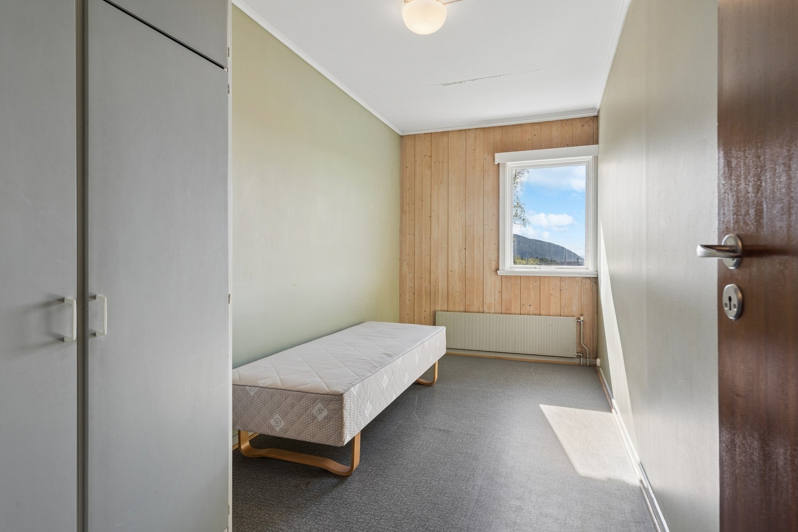 Soverom med trepanel på den ene veggen. Galleribilde